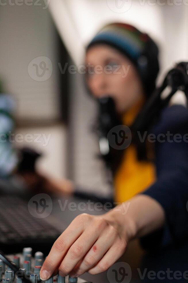 Close up of streamer wearing headset and talking into microphone with streaming comunity using professional mixer. Pro gamer playing online videogames with new graphics on powerful computer photo