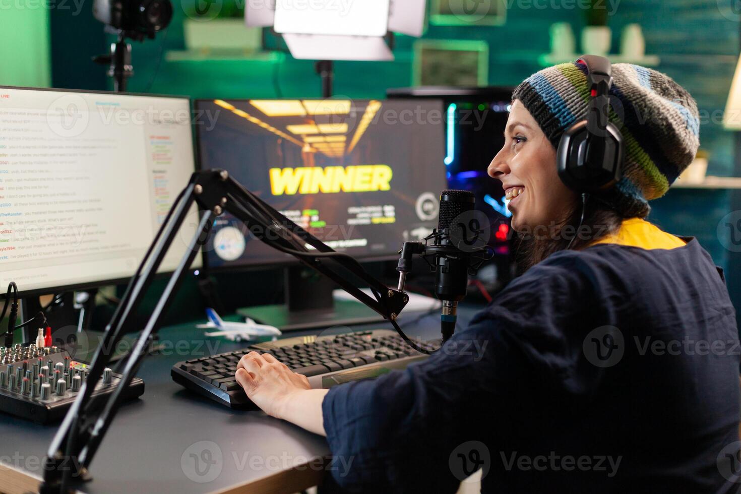 Back view of upseted streamer playing game competition using professional setup with streaming chat open. Gamer sitting on gaming chair using wireless controller and professional headphone photo