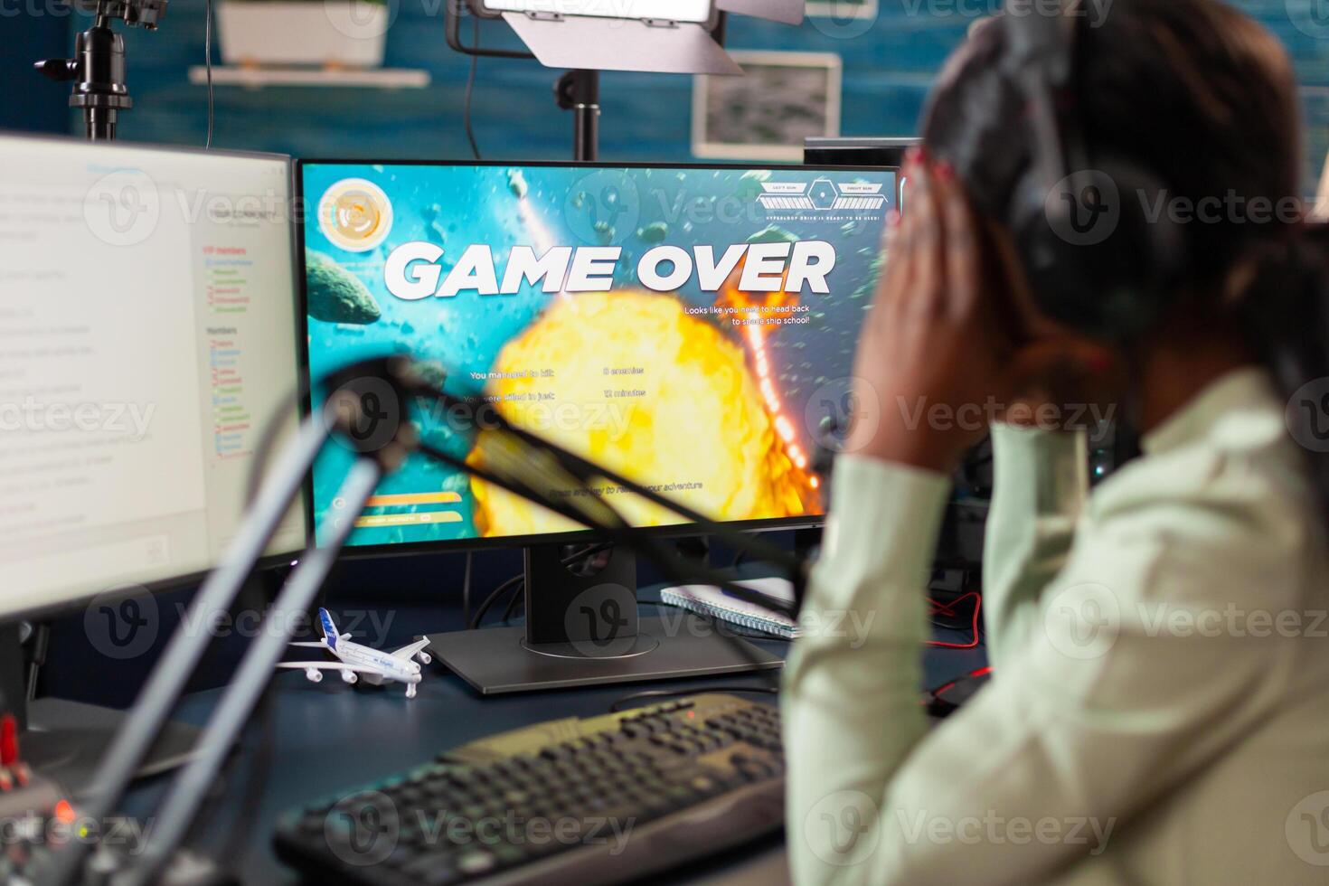 African esport player losing virtual tournament during live stream covering face. Professional gamer streaming online games with new graphics on powerful computer. photo