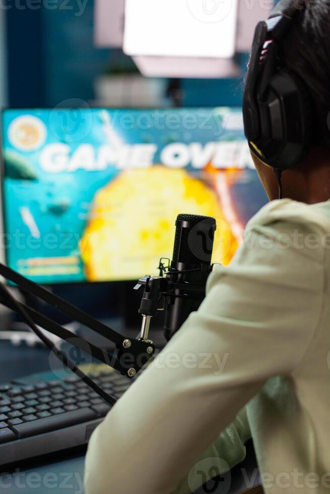 Afro streamer losing online championship being disappointed game over. Professional gamer streaming online games with new graphics on powerful computer. photo
