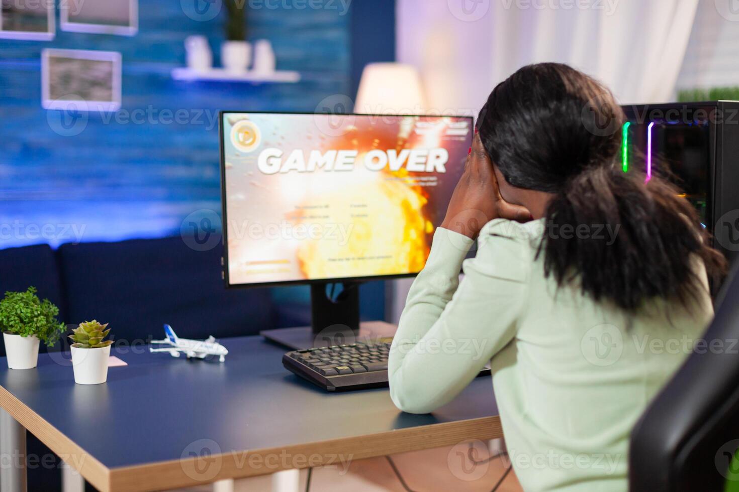 Disappointed sad african woman after losing online game competition Angry professional gamer gaming over during an space shooter online game. photo