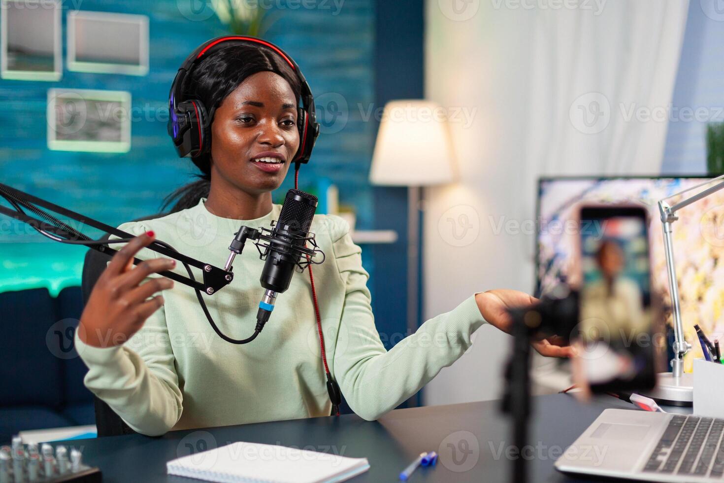 Influencer making online internet content for web subscribers in home podcast studio. Speaking during livestreaming, blogger discussing in podcast wearing headphones. photo