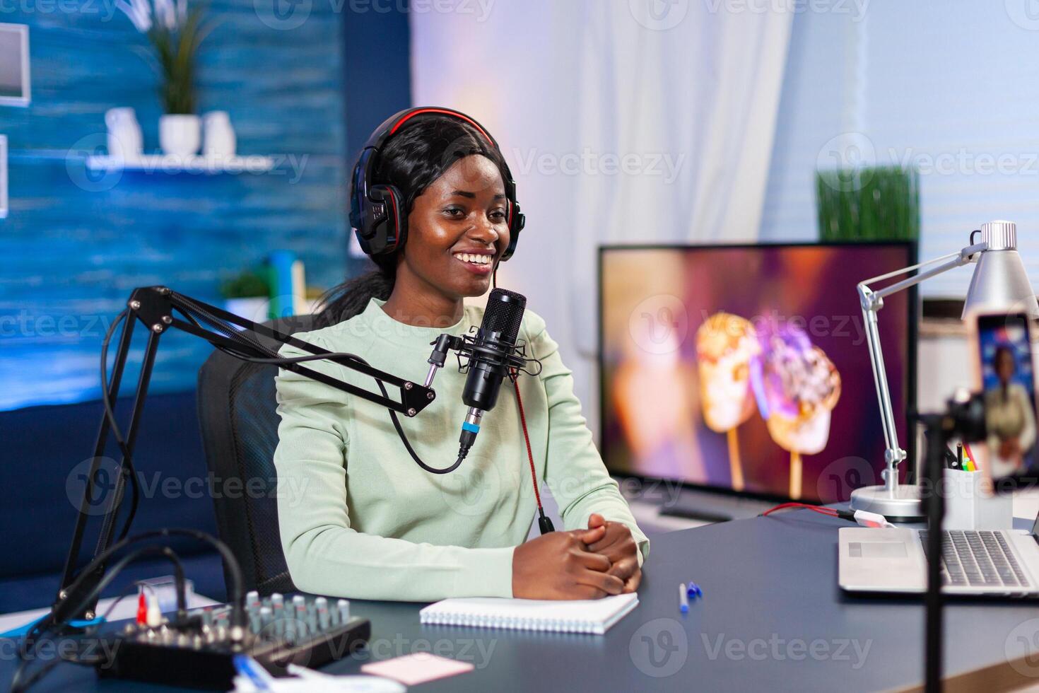 Social media star talking at camera and recording a new episode of show. Speaking during livestreaming, blogger discussing in podcast wearing headphones. photo