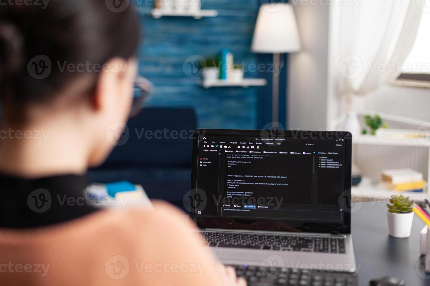 Young developer programming software typing html code deloping application for mobile use. Student working at infographics javascript using laptop computer while sitting at desk in living room photo