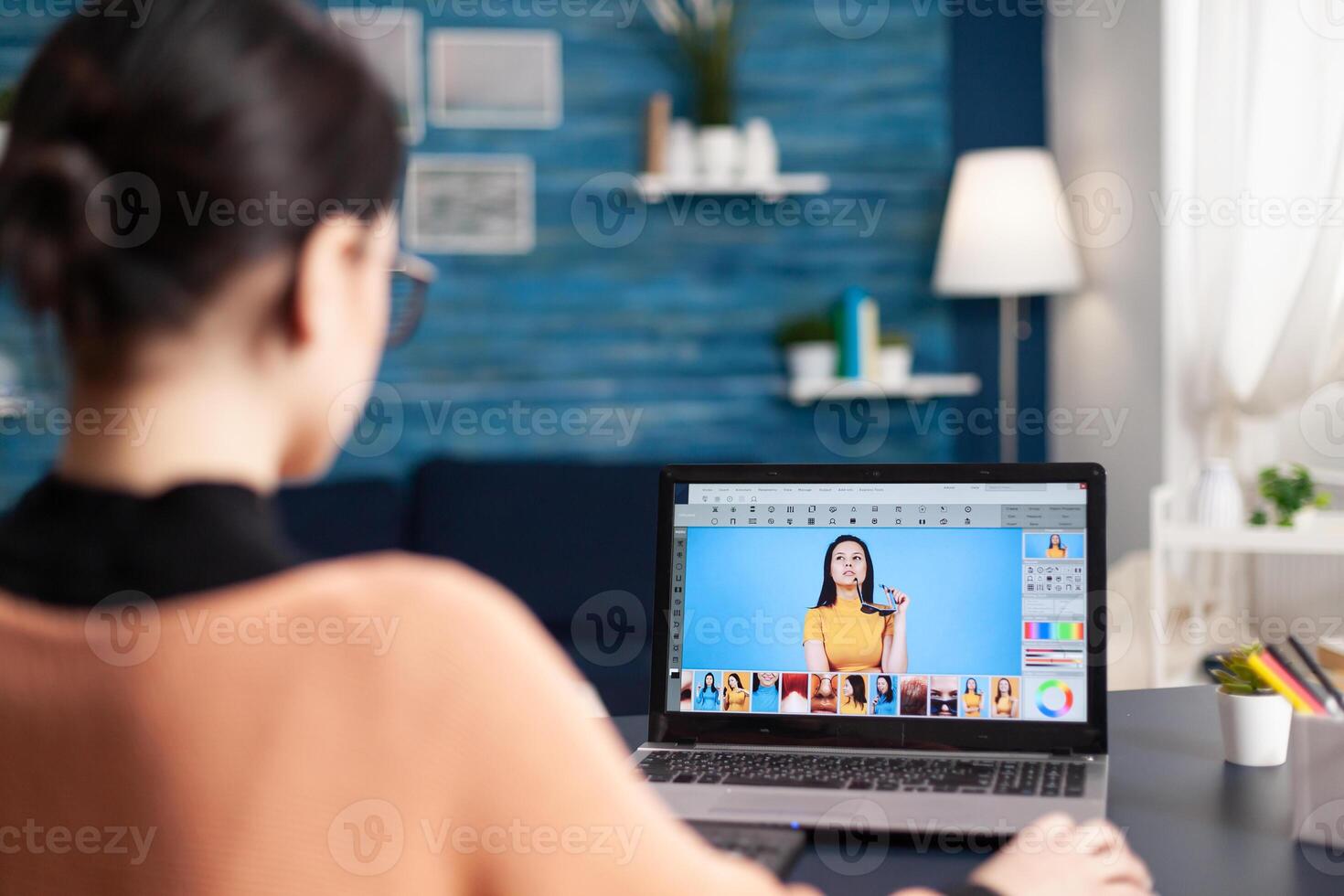 Student artist making color grade for creativity pictures working at post production photos. Photo editor retoucher sitting at desk table in living room using laptop computer studying photography