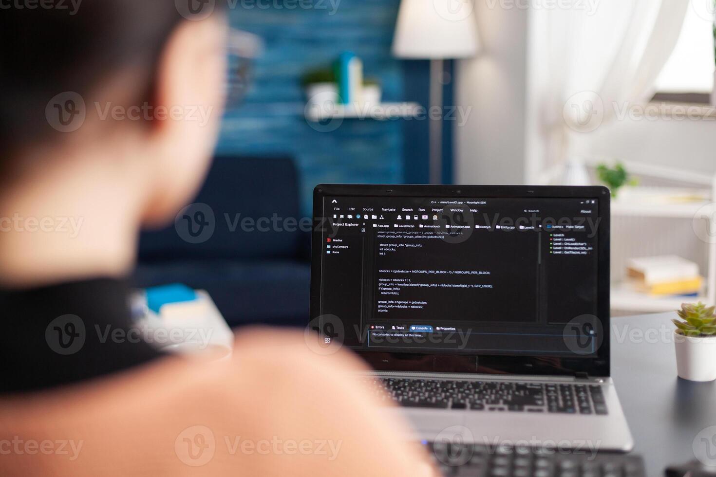 Young programmer writing virtual program code for software development and mobile application on laptop computer, Student programming javascript while sitting at desk table in living room photo