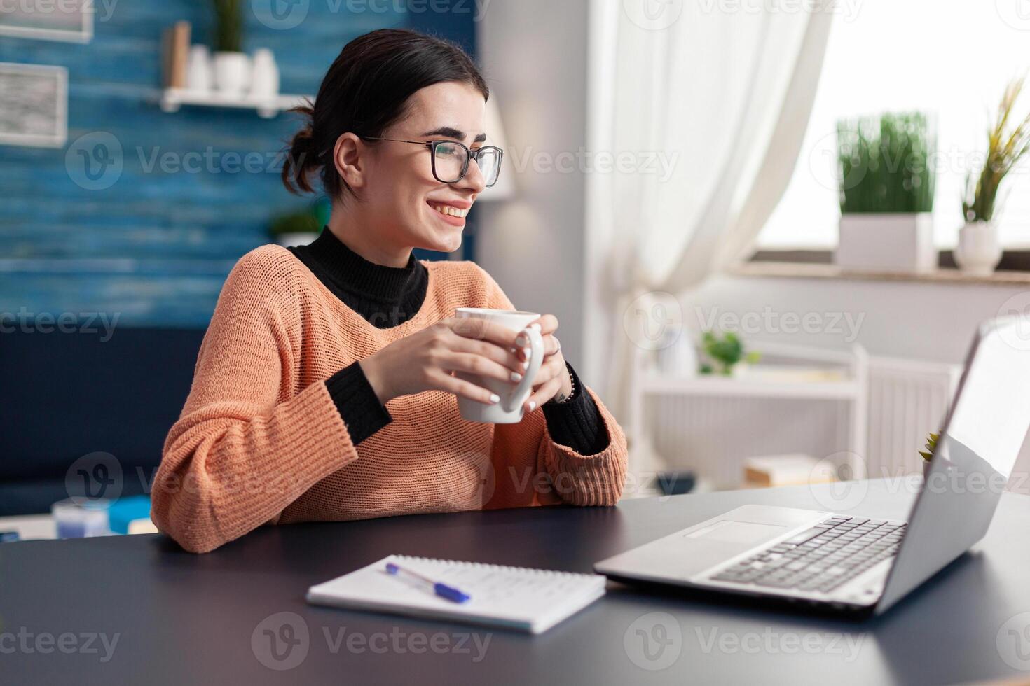 Student college looking at laptop computer searching for marketing information for homework. Woman browsing on e-learning university platform at desk in living room studying internet online communication photo