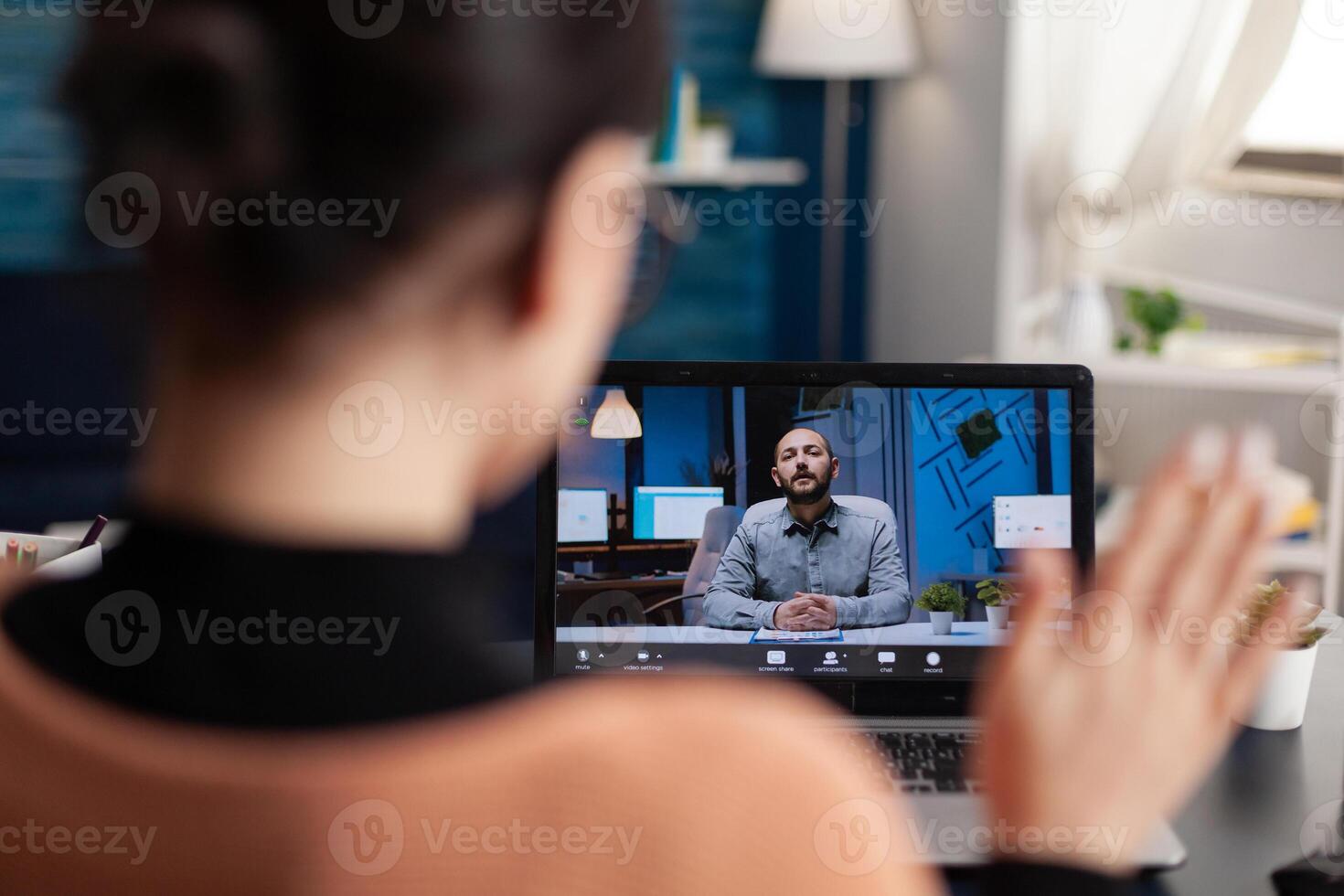 Student greeting her university teacher during virtual meeting using laptop computer. Caucasian female studying literature school webinar while sitting at desk table in living room photo