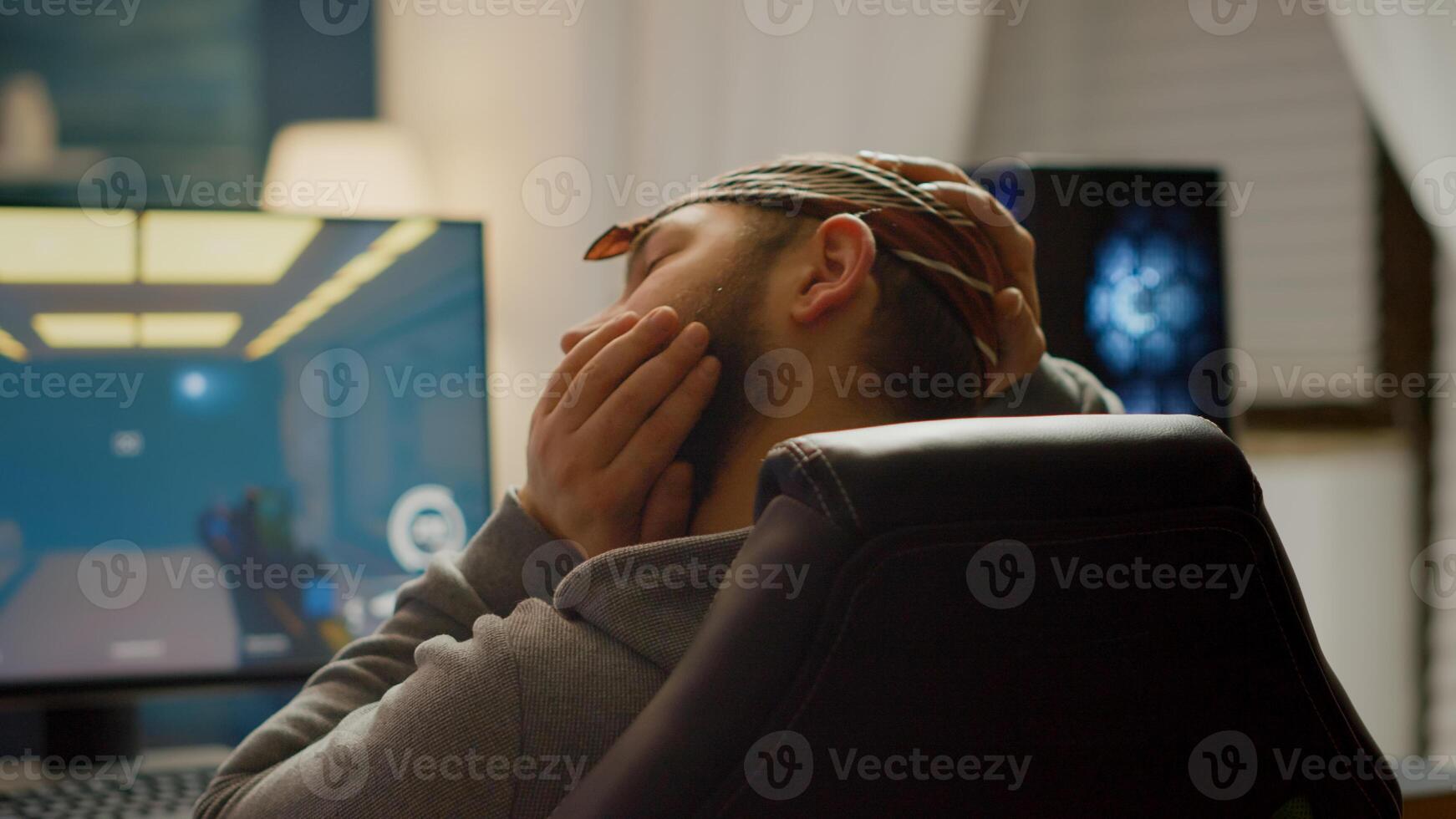 Back view shot of professional gamer playing in first-person shooter online game on powerful computer. Virtual championship in cyberspace, esports player performing during gaming tournament. photo