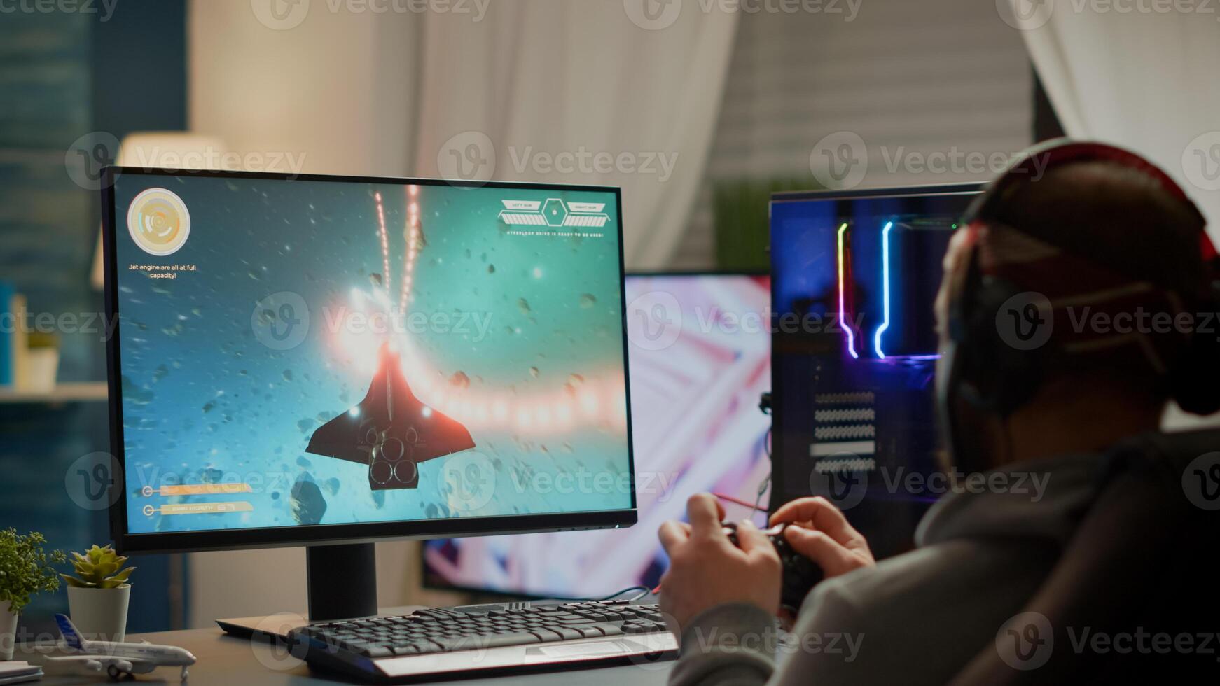 Gamer player with headphones and joypad performing space shooter game during gaming championship. Online streaming cyber performing at virtual esports tournament using wireless joystick photo