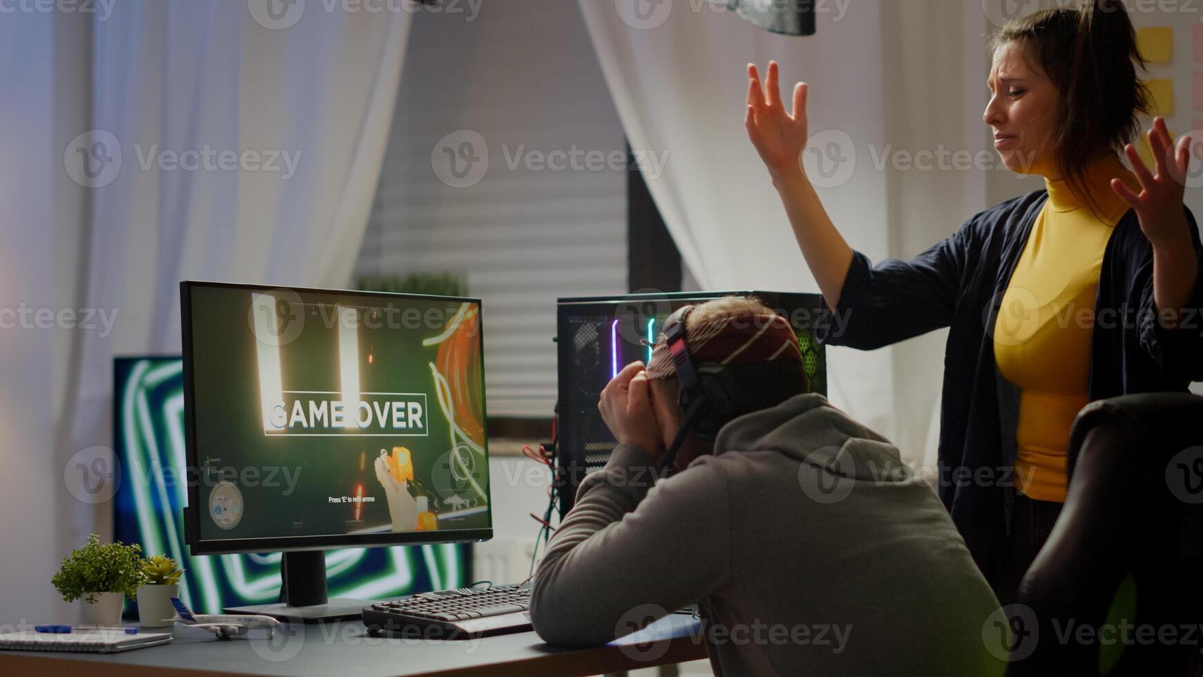 Professional couple of gamers losing first person shooter game playing on powerful personal computer for online championship. Sad cybers performing in gaming room during virtual tournament photo