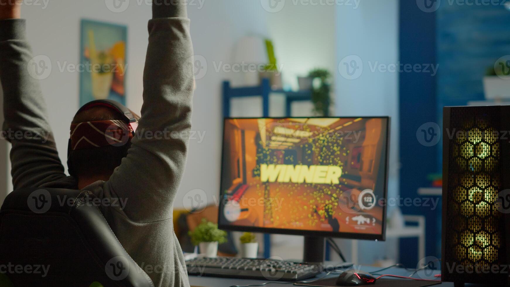 Back shot of happy man gamer wining first person shooter game playing on powerful personal computer. Online streaming cyber performing during gaming tournament using technology network wireless photo