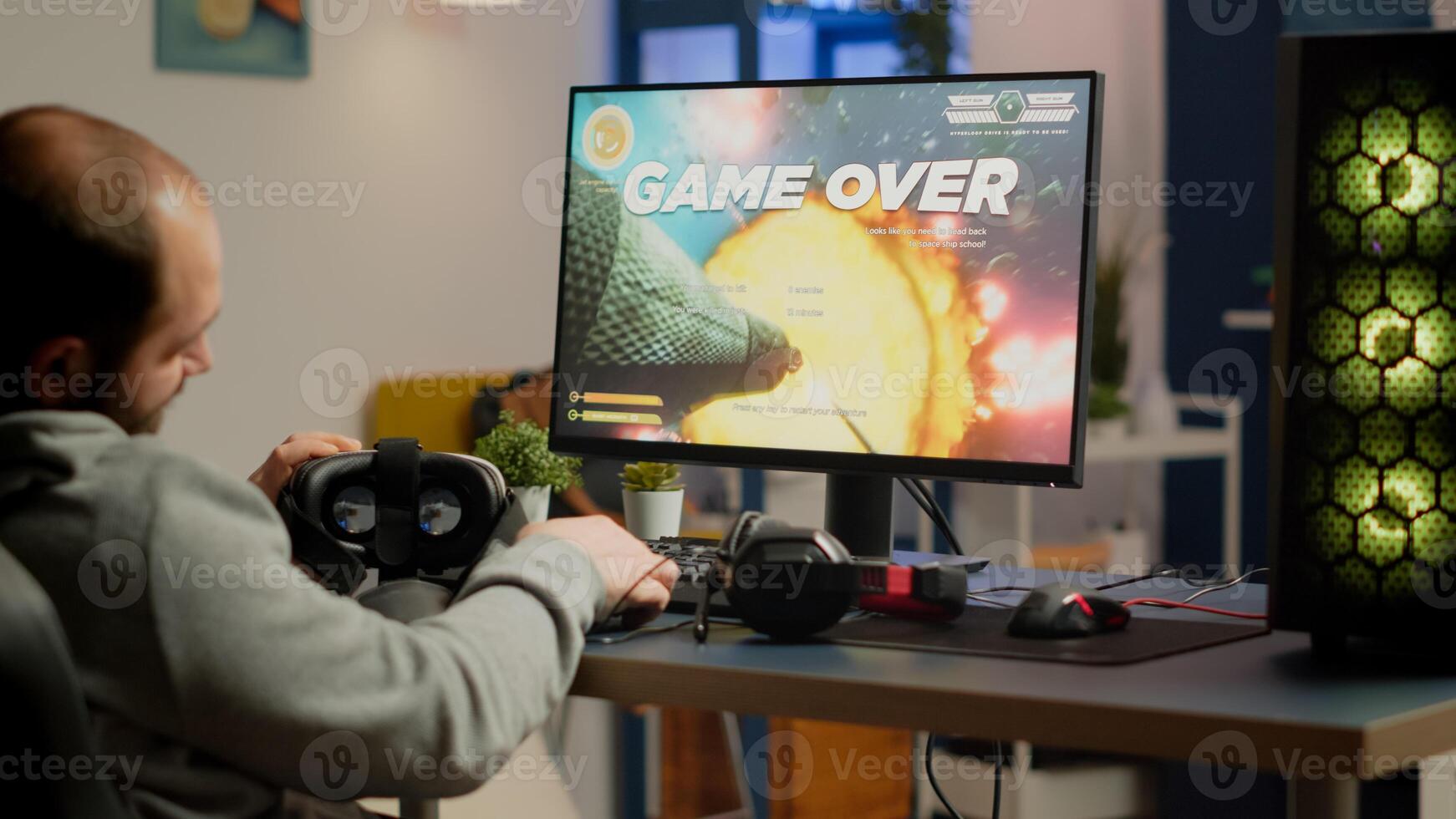 Videogamer losing graphics cyberspace game sitting on gaming chair using wireless controller and VR headset playing on powerful computer. Sad pro cyber man streaming online championship photo