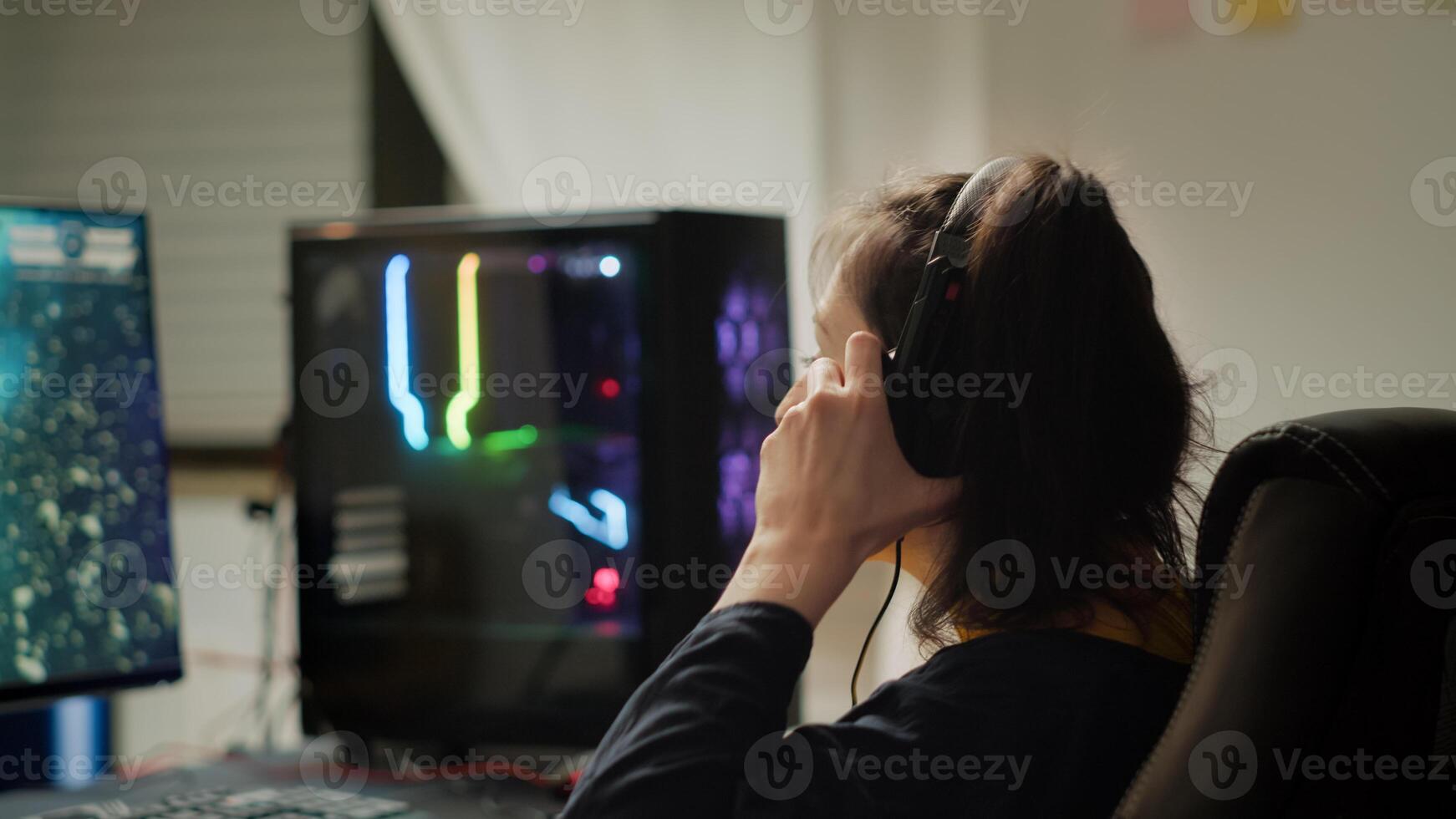 Professional eSport gamer with headset playing in competitive games on cyber gaming tournament. Virtual championship in cyberspace, esports player performing on RGB powerful personal computer photo