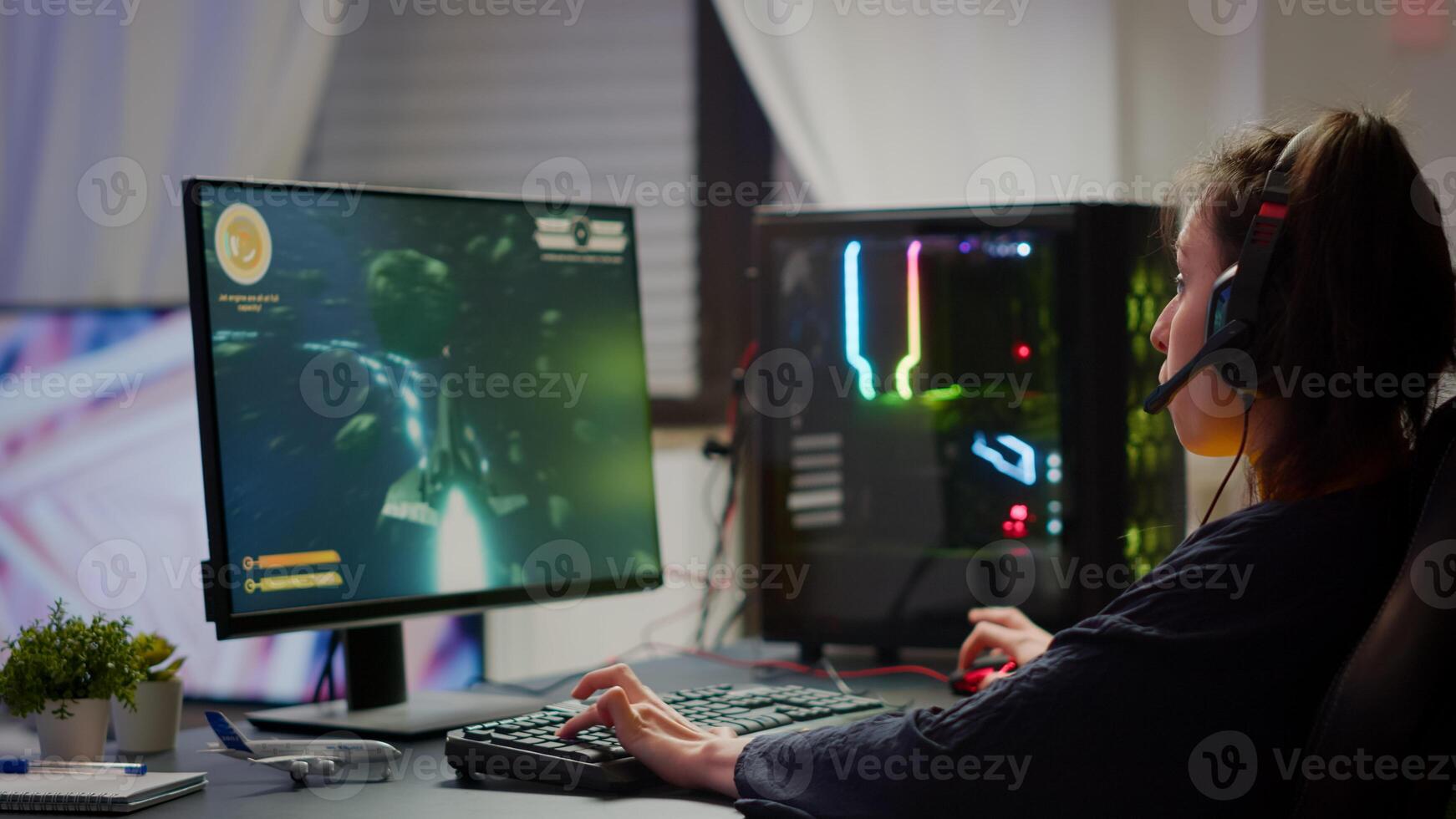 Excited professional esport gamer celebrating championship victory, woman winning space shooter game. Pro cyber gaming online tournament live streaming championship using RGB powerful computer photo
