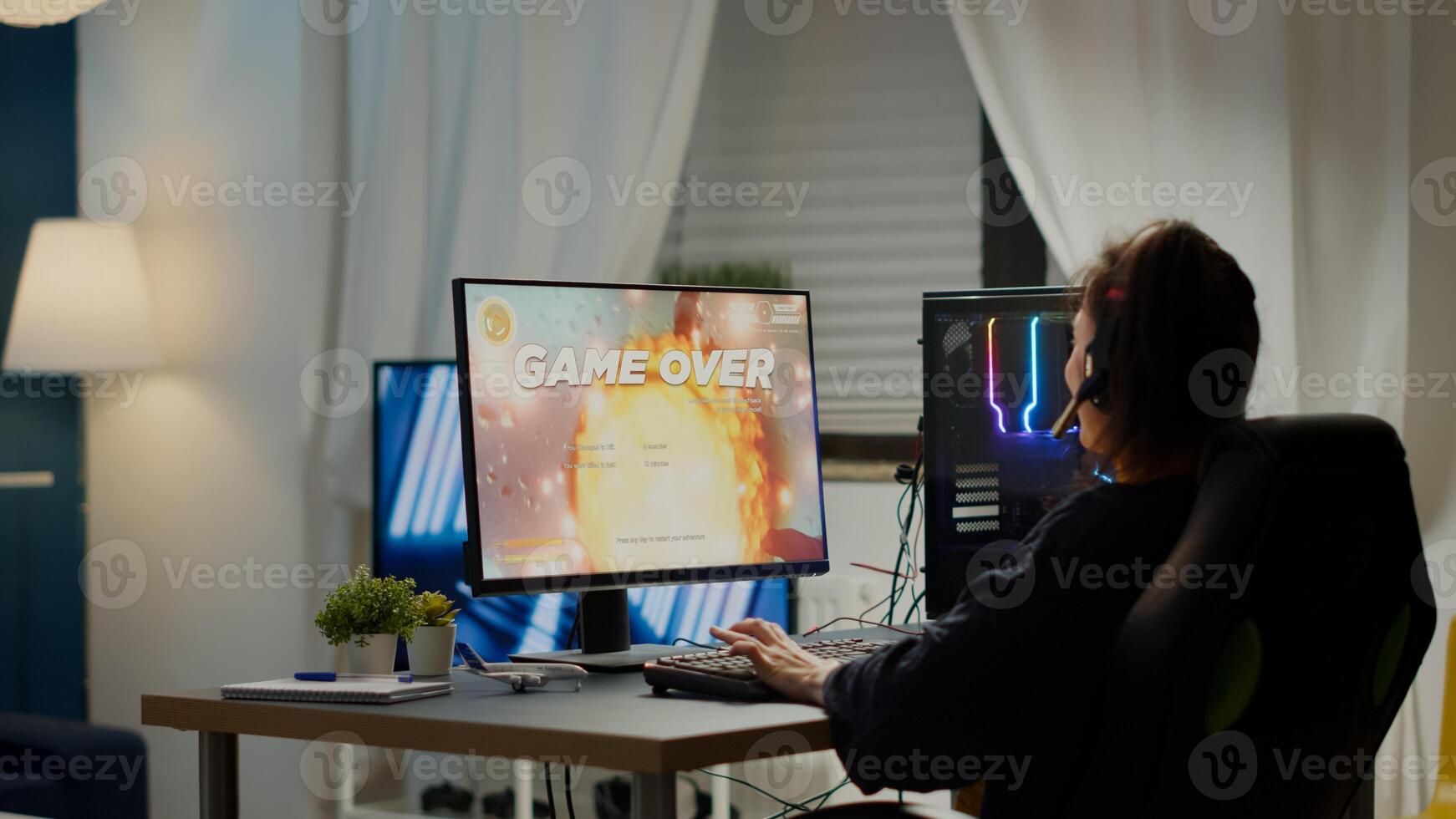Furious pro woman gamer with headset losing space shooter game with new graphics during gaming championship playing from home at RGB powerful personal computer, performing at esports tournament photo