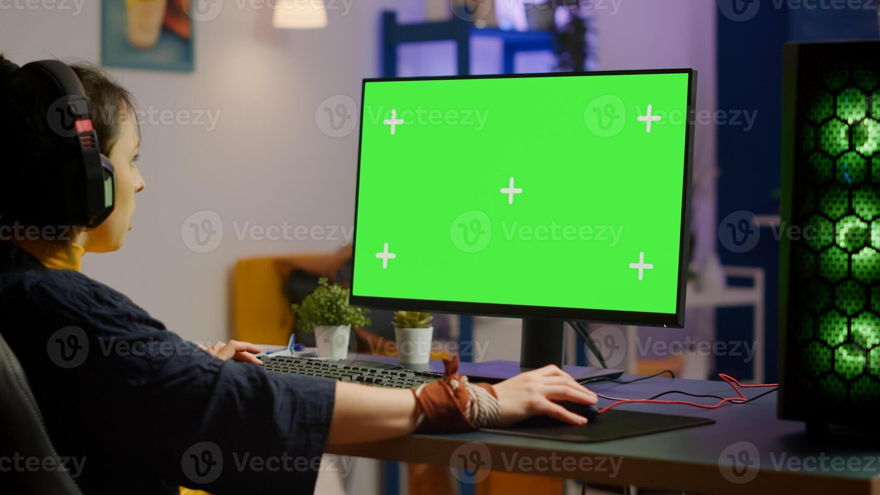 Pro woman player gaming on powerful computer with green mock up chroma key screen while streaming online competition. Gamer using pc with greenscreen isolated desktop streaming shooter games photo