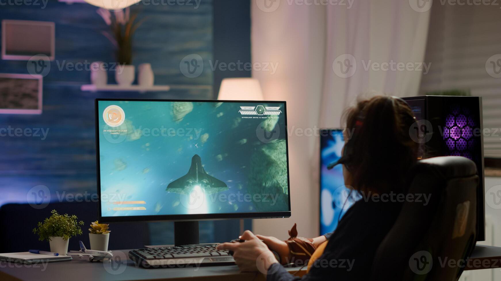 Back shot of pro gamer playing online space shooter game on powerful computer using wireless controller. Competitive cyber player woman performing game tournament use professional joystick photo