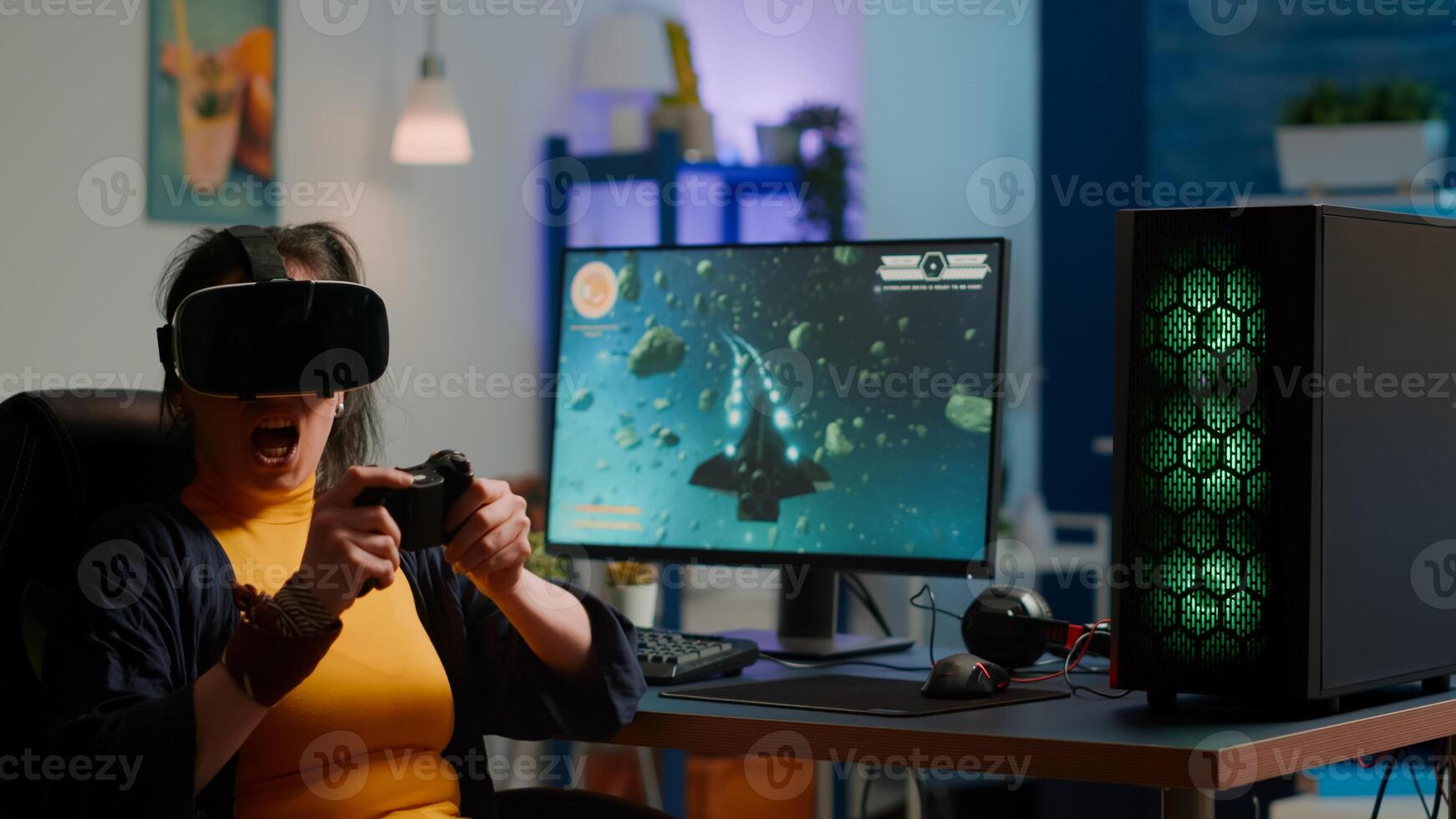 Videogame player with vr goggles raising hands after winning space shooter competition wearing headset dancing. Professional pro cyber woman playing online game with new graphics on powerful computer photo