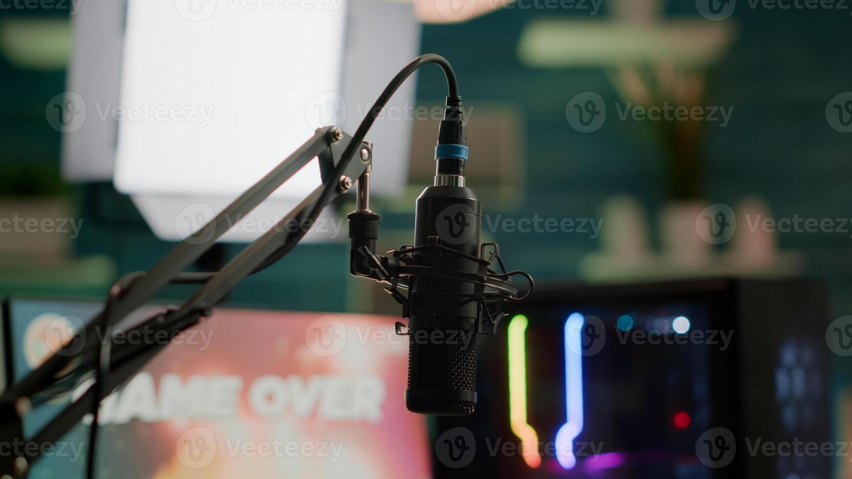 Streaming professsional microphone in empty gaming home studio with neon lights. Game is over on display of RGB professional powerful computer and stream chat is prepared for virtual tournament photo