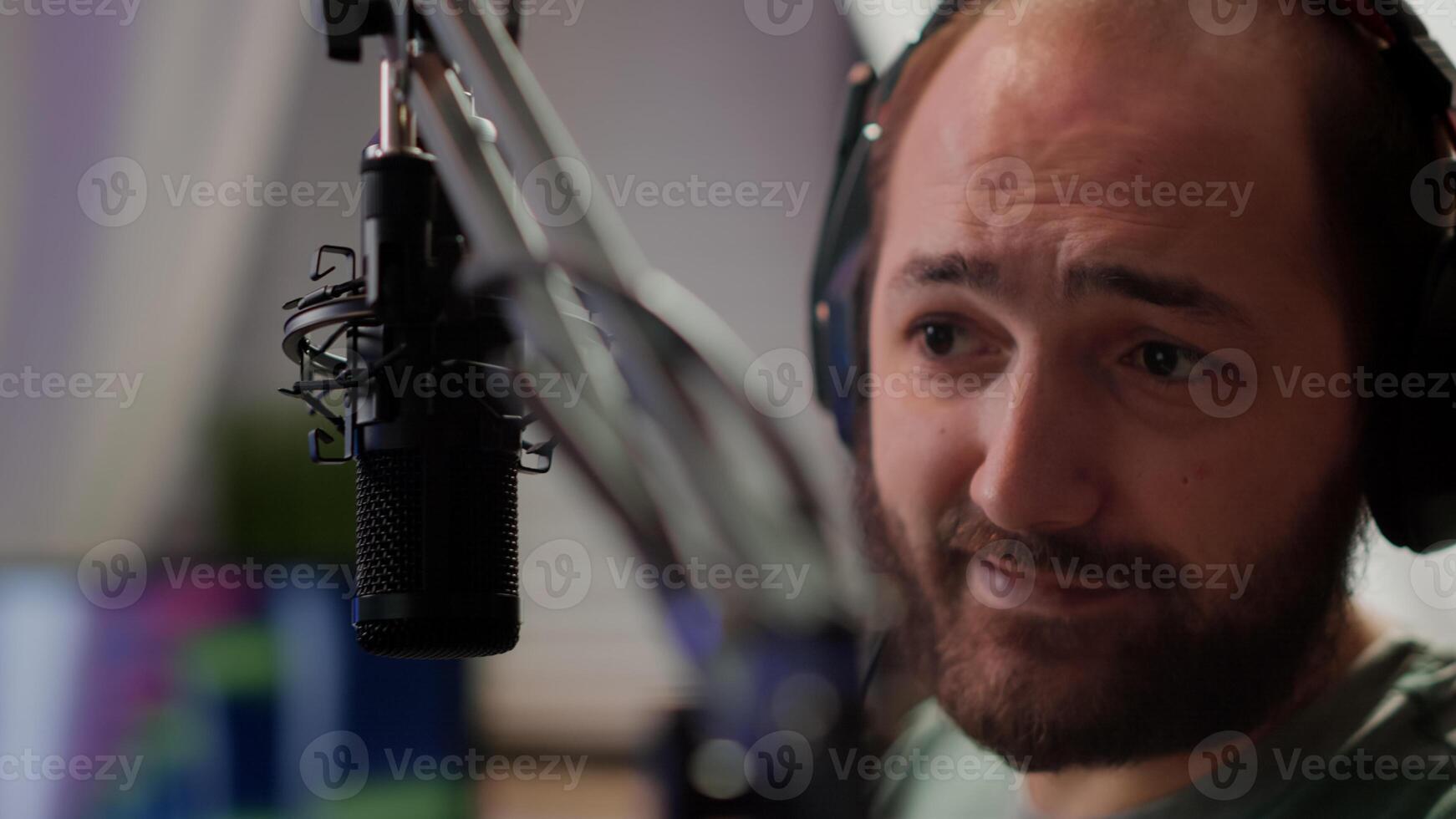 Close up of pro streamer sitting on gaming chair discussing with players at professional micorphone playing space shooter game during online tournament. Portrait of cyber talking on stream chat photo