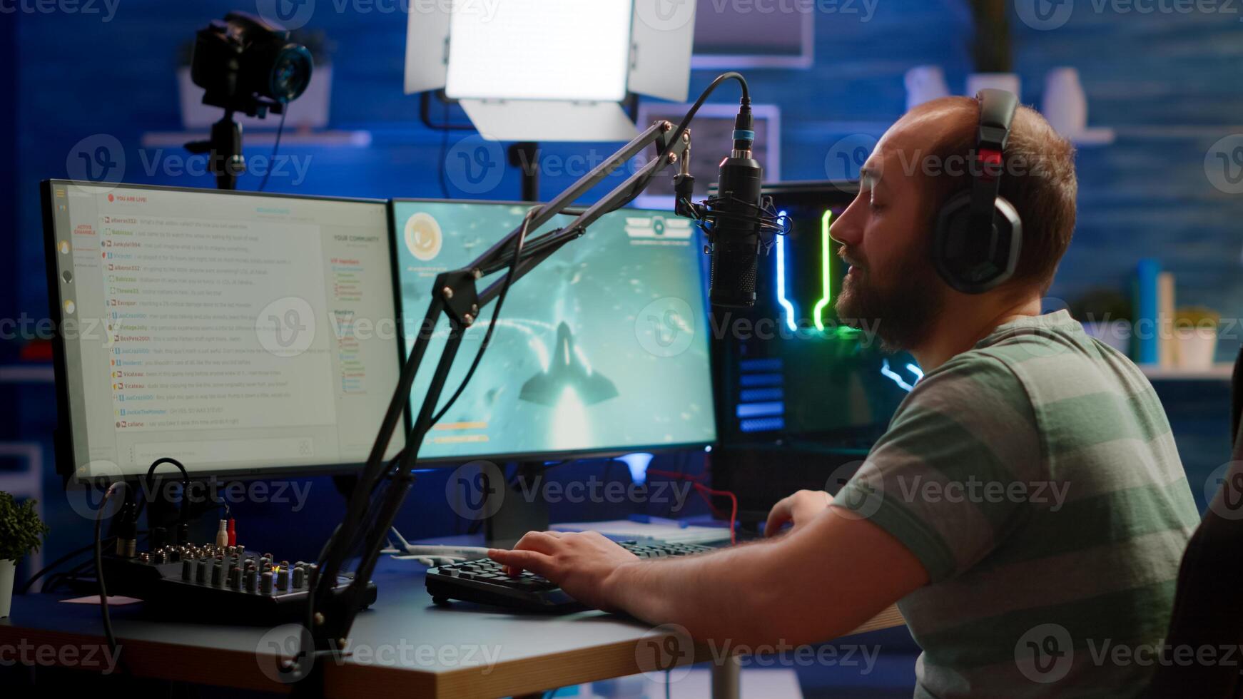 Competitive gamer with headphones using stream chat on powerful computer playing online shooter game late at night. Virtual online streaming cyber checking sound performing in gaming tournament photo