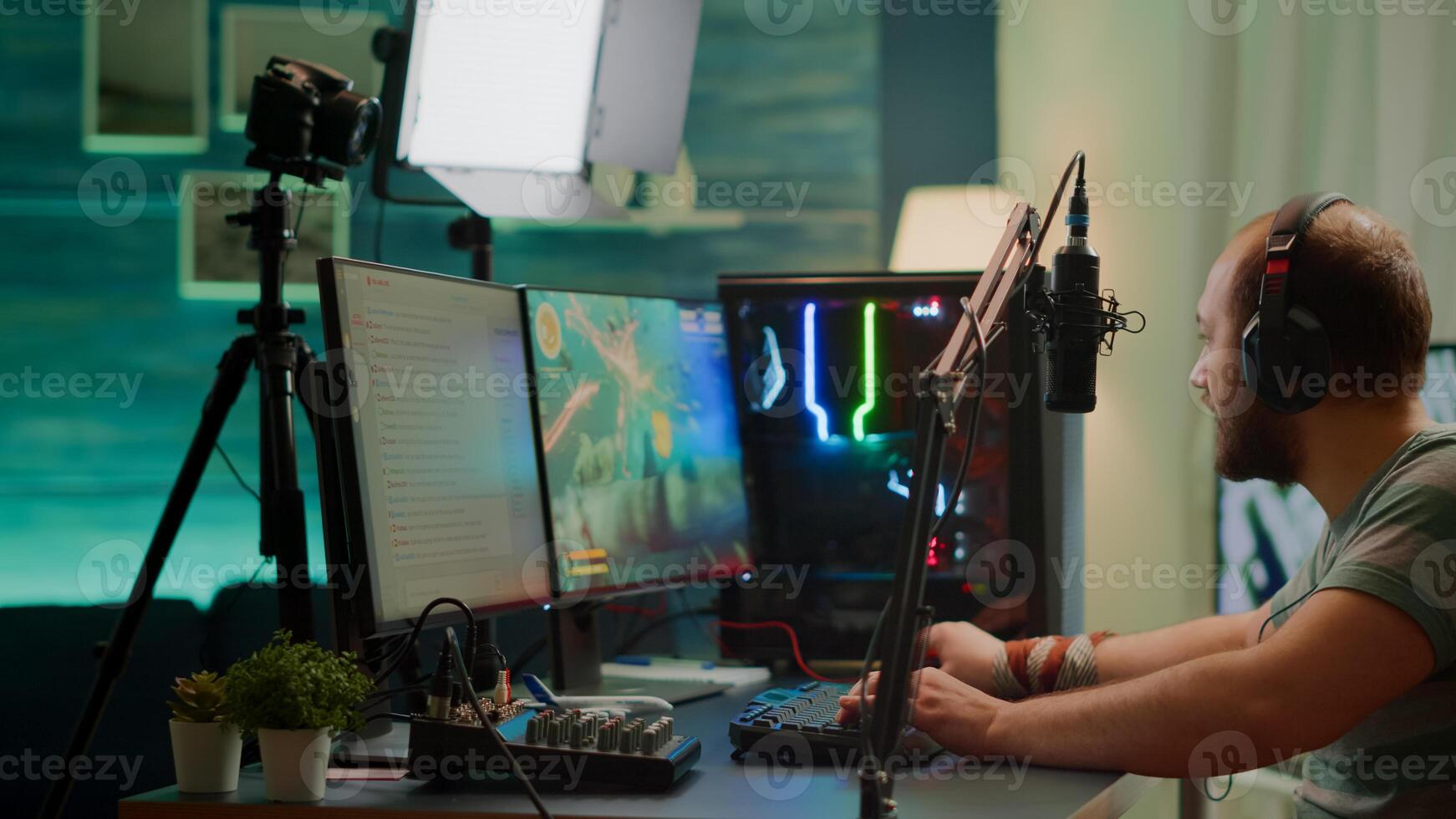 Competitive player streaming esport tournament checking sound mixer, stream chat and professional microphone. Competitive man playing online space shooter gaming competition on powerful computer photo