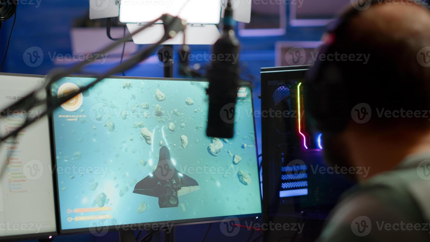 Close-up of streamer man talking at microphone with other players during space shooter tournament. Online streaming cyber performing games competition using technology network wireless photo
