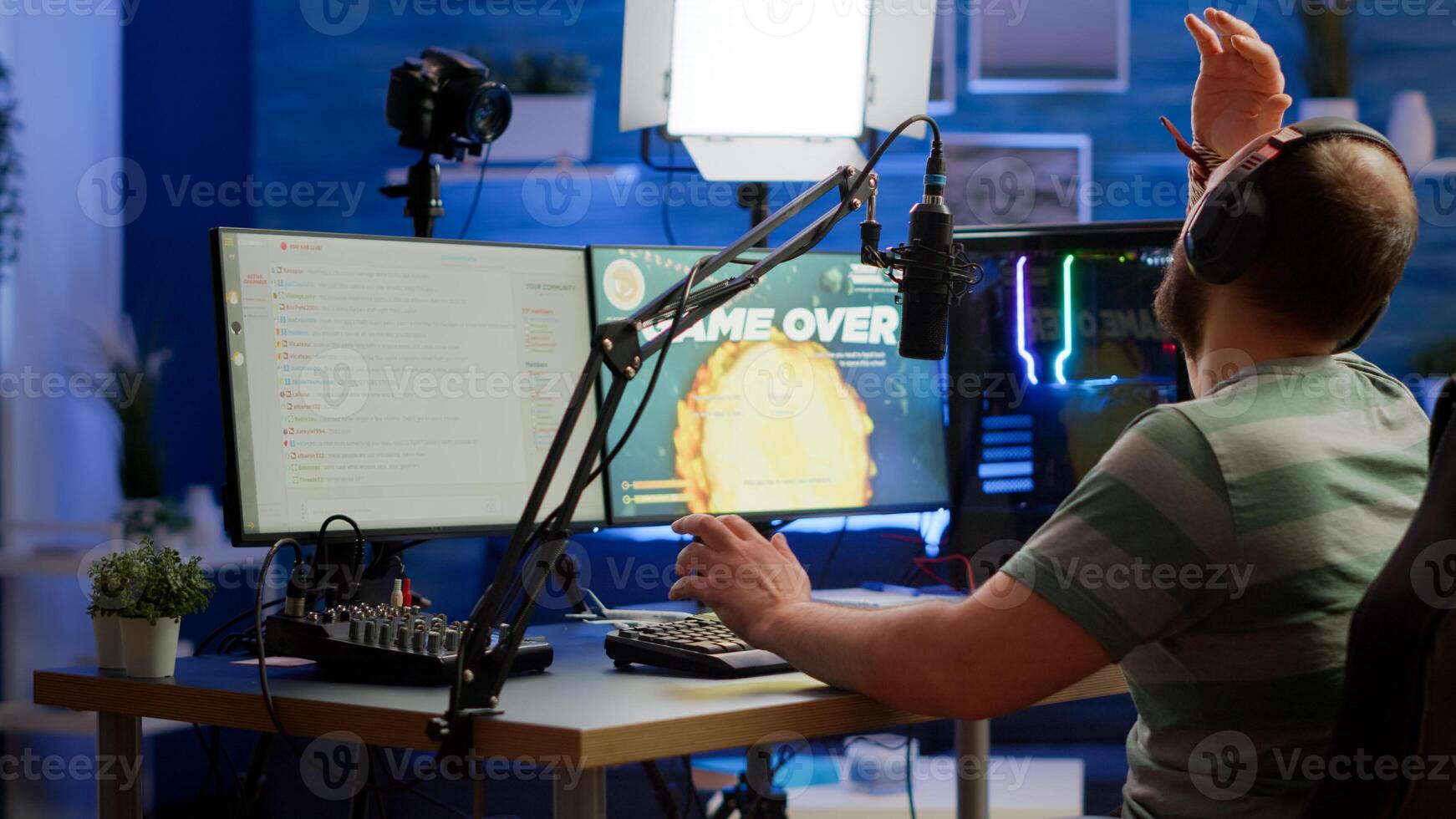 Videogame streamer losing online videogame competition wearing professional headset talking on stream chat. Sad gamer using powerful computer for gaming tournament late night playing space shooter game photo