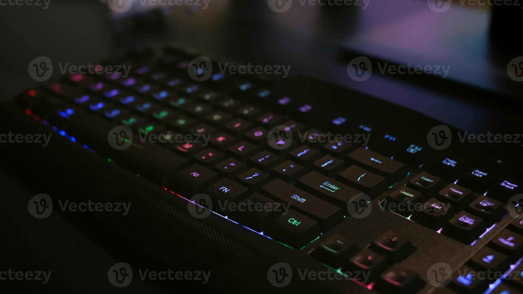 Close-up of professional keyboard with RGB lighting during online gaming tournament. Home studio of esport game player using powerful gaming PC photo