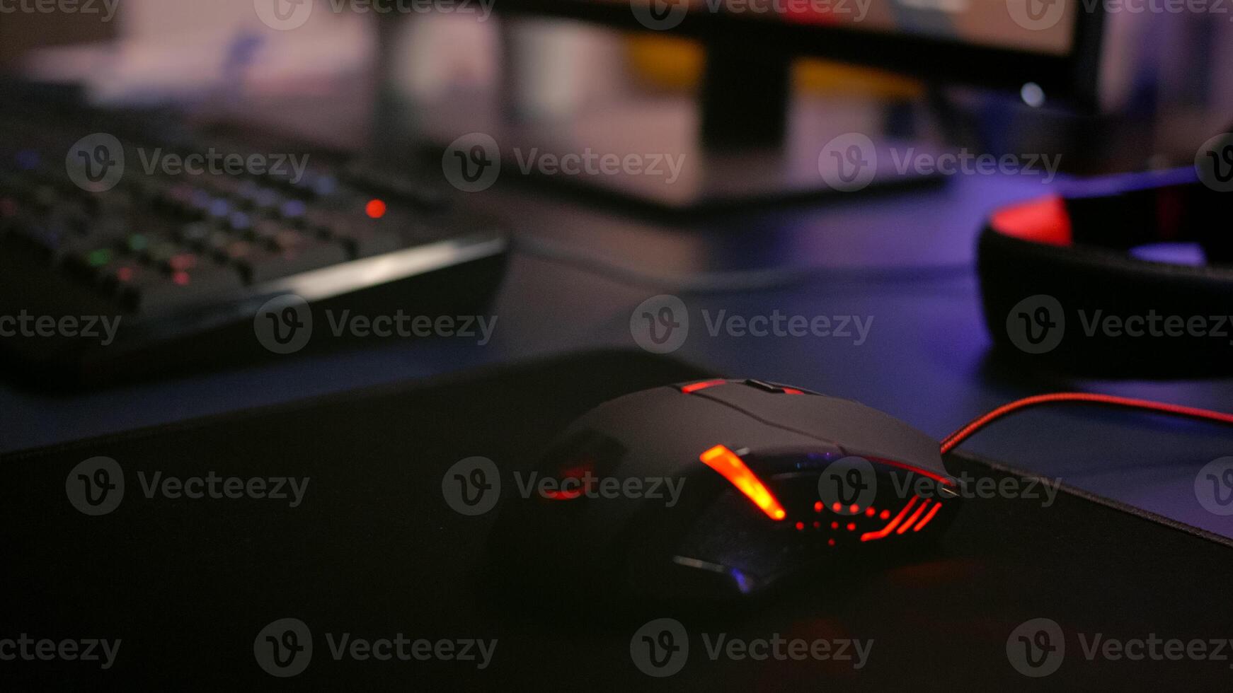 Closeup of professional mouse with RGB lighting during online shooter games tournament. Home studio of esport game player using powerful gaming PC photo