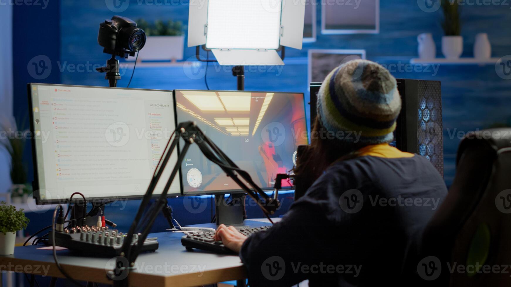 Streamer coming in gaming room playing videogames and talking with team mates on streaming open chat and microphone, checking sound mixer. Cyber performing on powerful computer professional equipment photo
