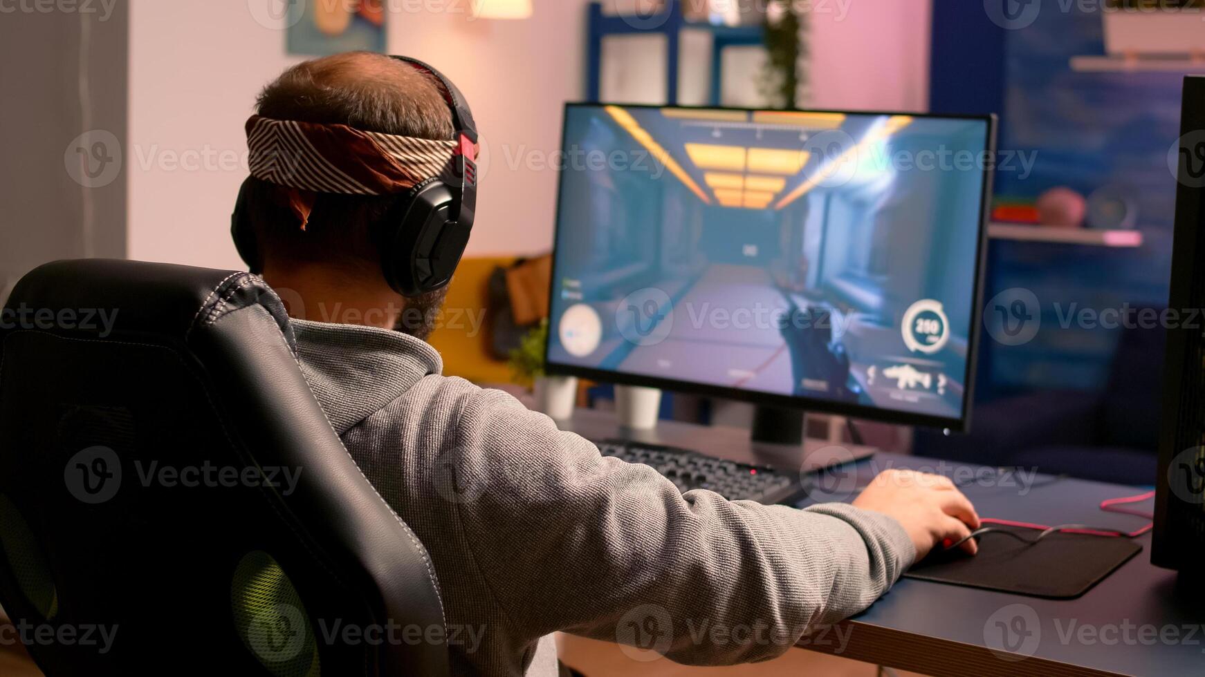 Cyber gamer stretching hands and neck before playing online games using RGB keyboard and mouse. Player performing online games during gaming tournament photo