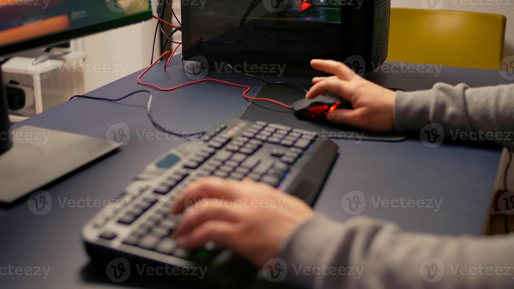 Closeup of player hands using RGB keyboard in gaming home studio. Digital gamer using professional equipment for first shooter game person competition late at night in living room photo