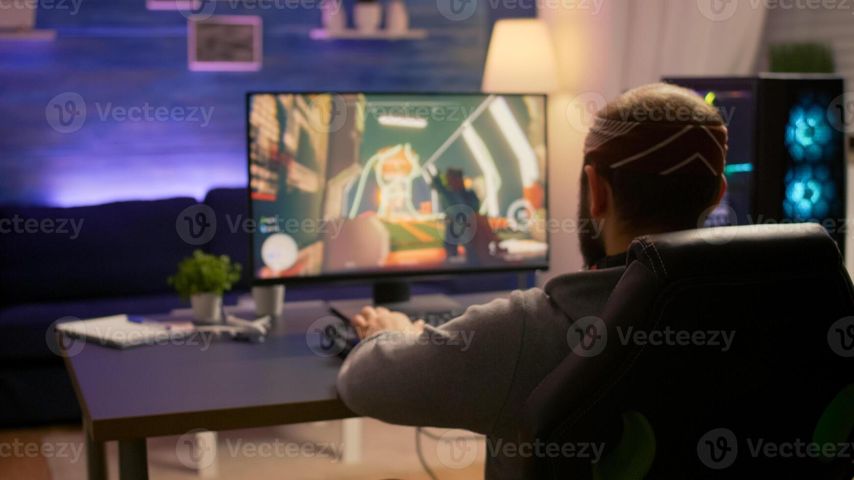 Pro gamer playing first person shooter game at gaming home studio using RGB mouse keyboard. Virtual online streaming setup with neon lights cyber performing during game tournament photo