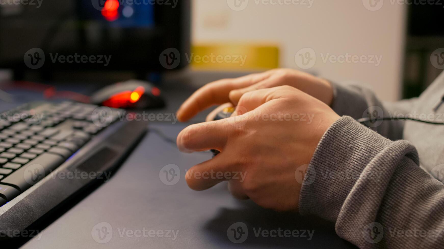 Close-up of wireless joystick during online championship in gaming hone studio. Competitive player man playing game tournament with new graphics using professional RGB equipment photo
