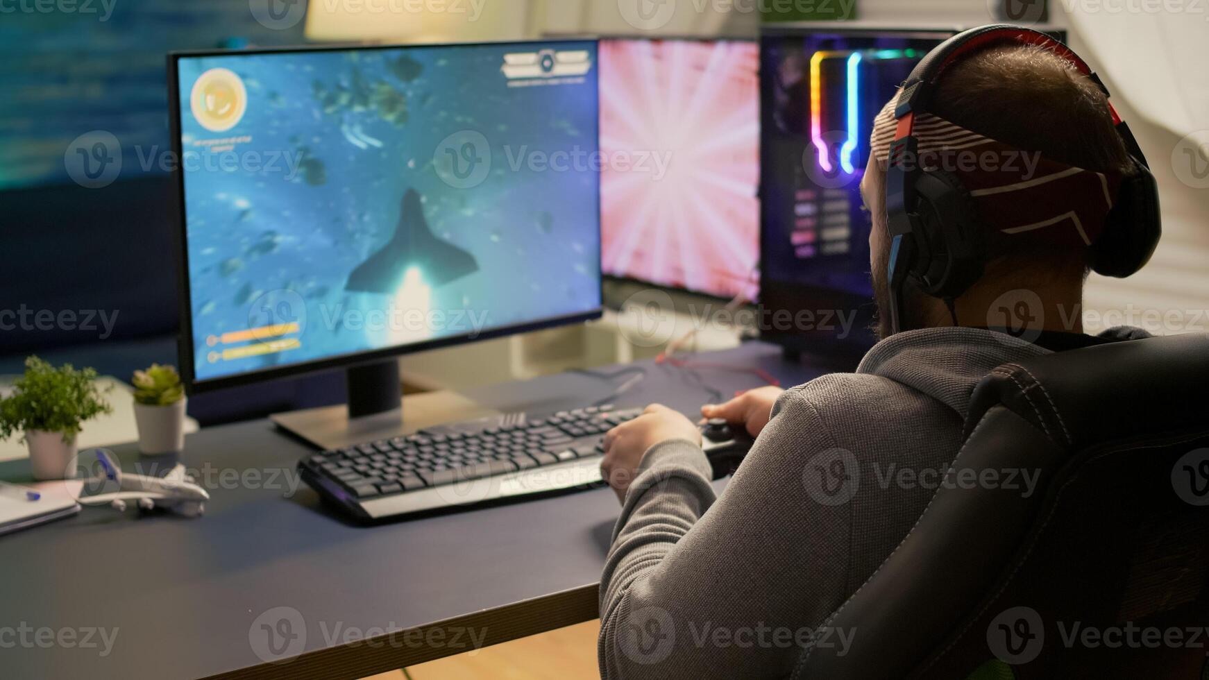 Back shot of pro gamer playing online space game on powerful computer using wireless controller. Competitive player man using professional RGB equipment during game tournament photo