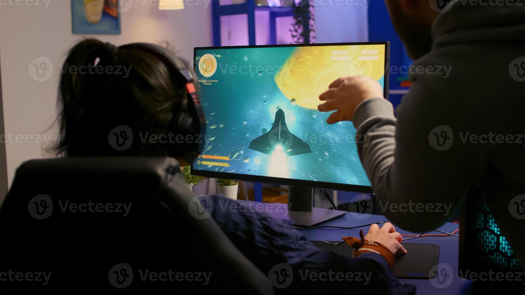 Couple of gamers playing multiplayer game on powerful computer at home with professional headphones. Online streaming cyber performing during gaming tournament using technology network wireless photo