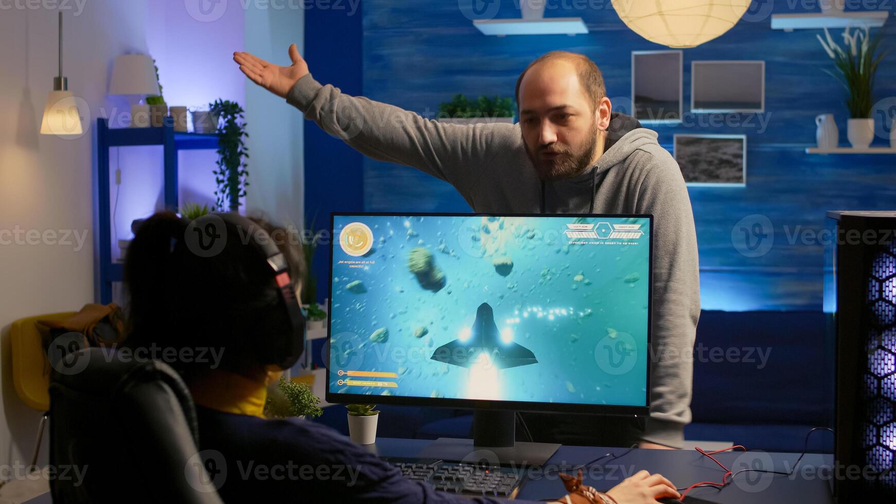 Woman gamer playing space shooter game and fight with her boyfriend about online tournament. Competitive player streaming game tournament using professional equipment at home gamming studio photo