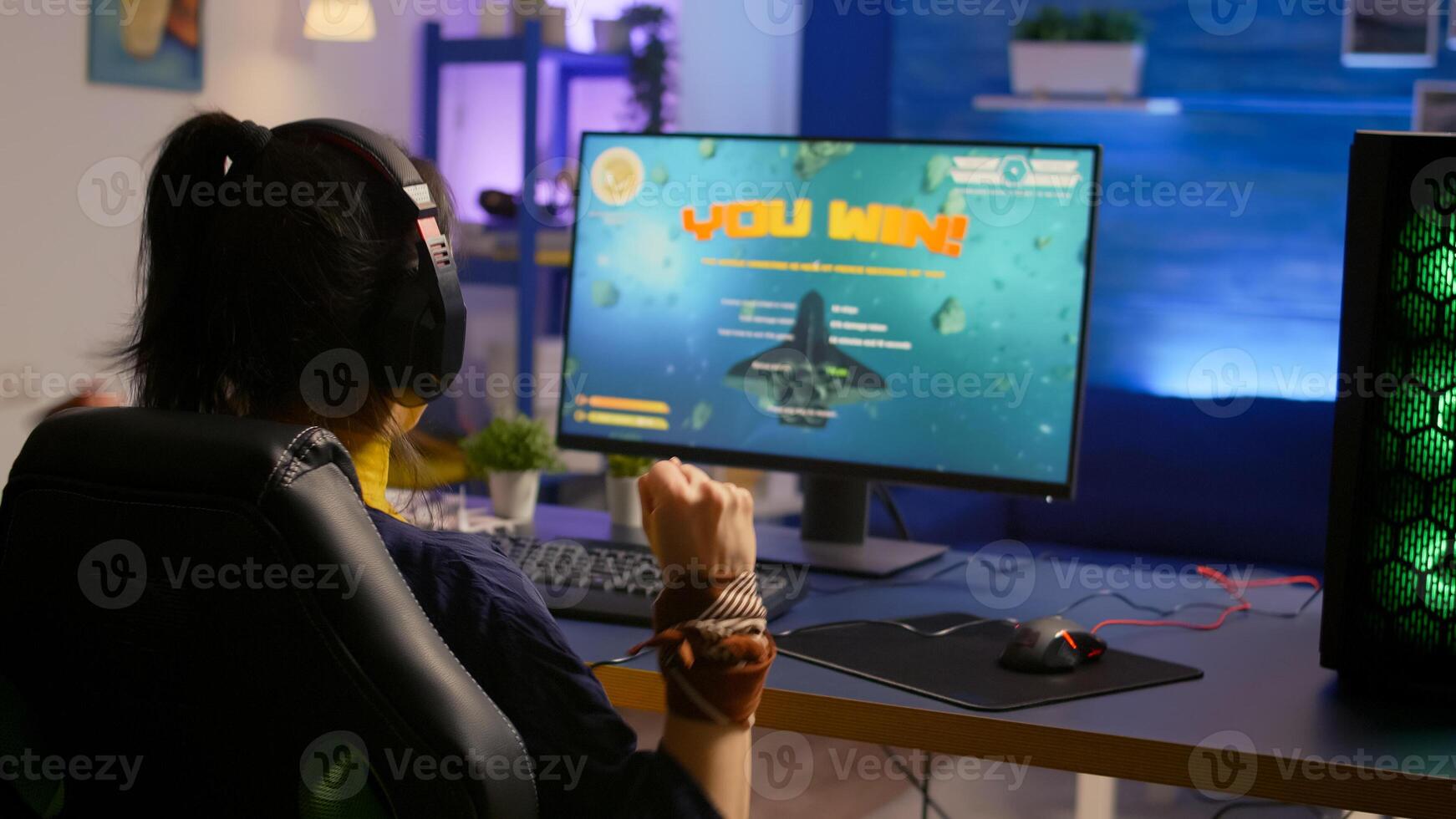 Player winning space shooter esport tournament wearing professional headset. Cyber performing on powerful computer late at night in gaming room home during online tournament photo