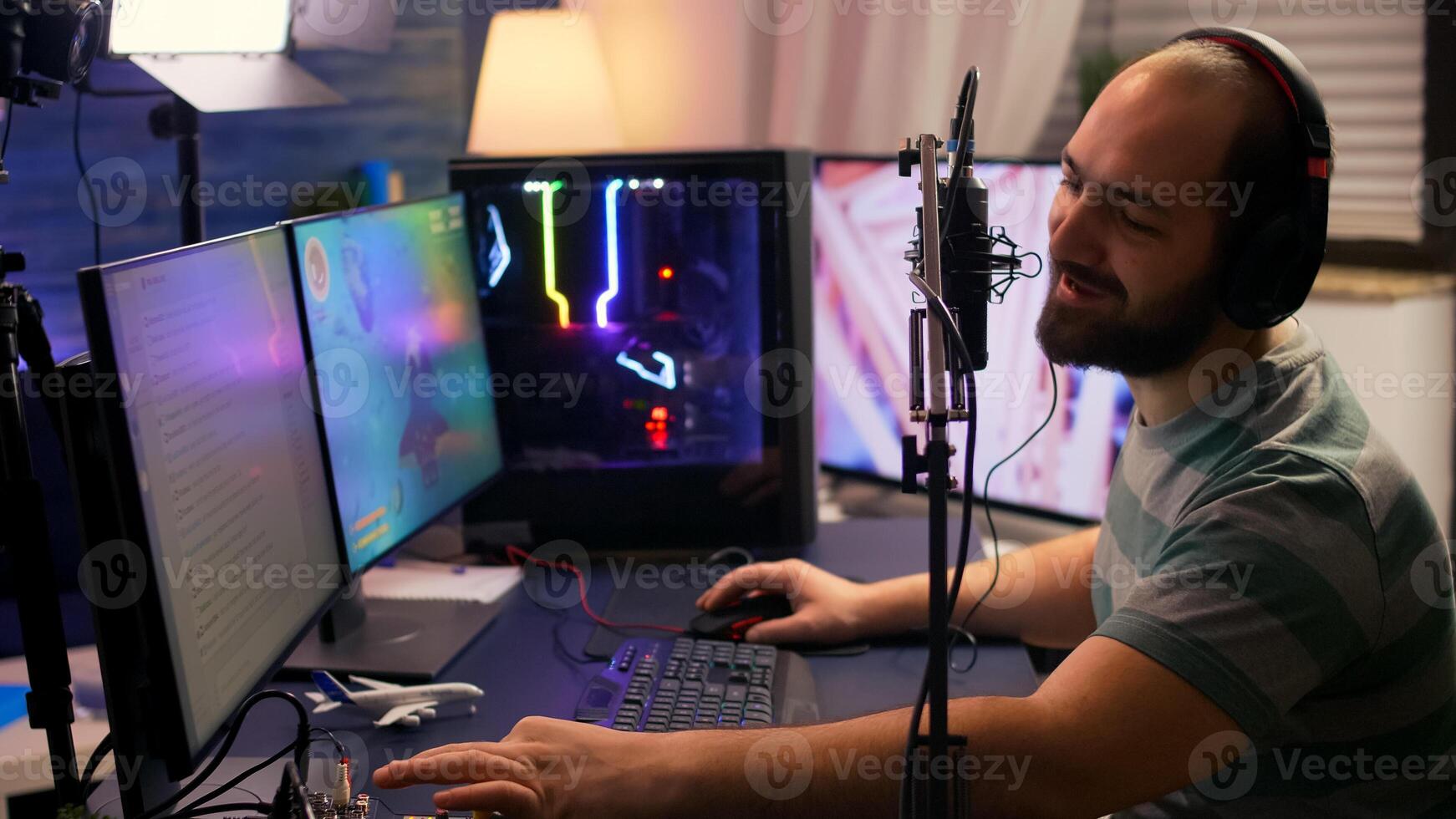 Streamer cyber performing space shooter game on powerful pc talking with players on chat open during professional competition. Player man using professional headphones in streaming home studio photo