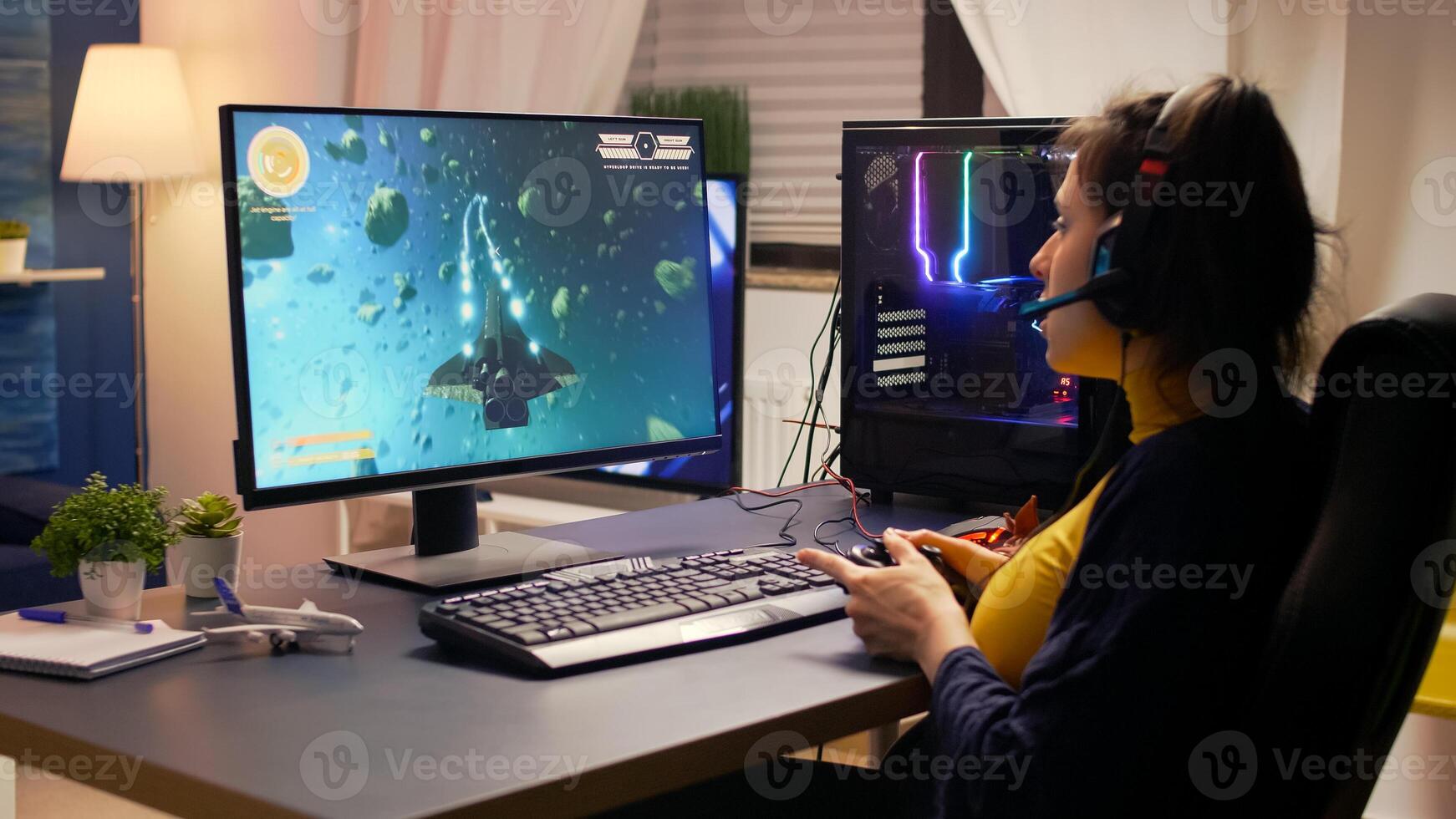 Competitive cyber gamer winning online game tournament wearing professional headset. Pro player using joypad for space shooter championship sitting on gaming chair late at night in living room photo