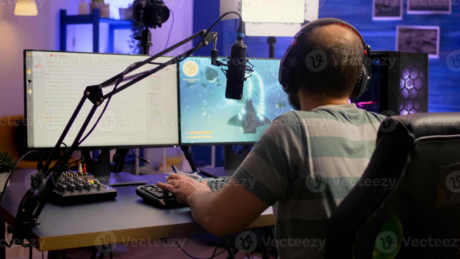 Pro esport streamer using headphones and talking with team on streaming services during space shooter competition. Virtual game in cyberspace, esports player performing on powerful computer photo