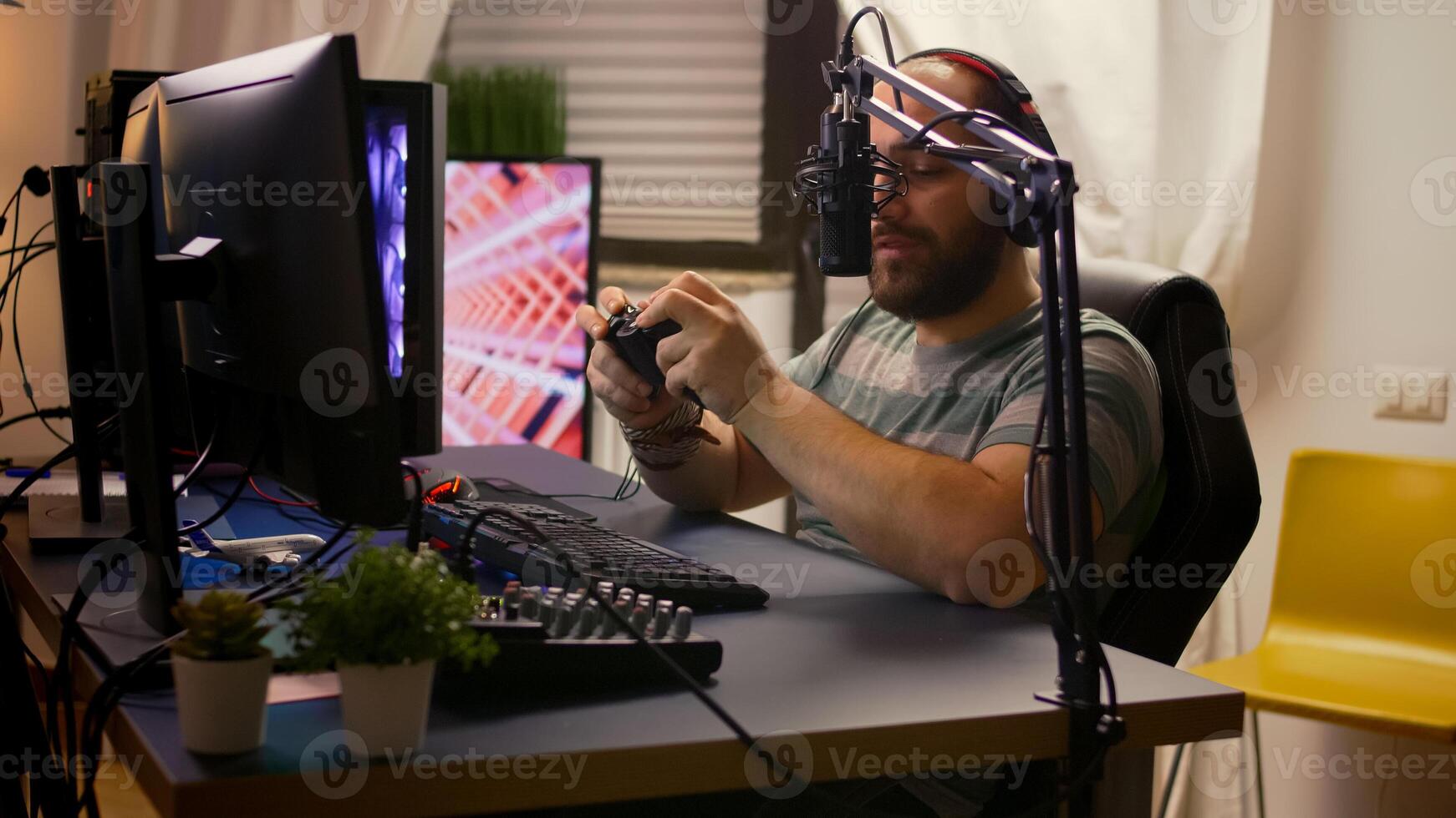 Side view of pro streamer man with headphones playing online games with streaming chat open. Cyber performing on powerful computer in gaming room home using professional console photo