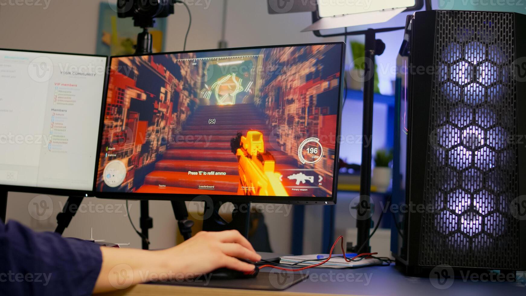 Close-up of streamer playing first person shooter game using RGB keyboard and mouse. Gamer talking on streaming chat with other players during esport tournament late at night in gaming studio photo