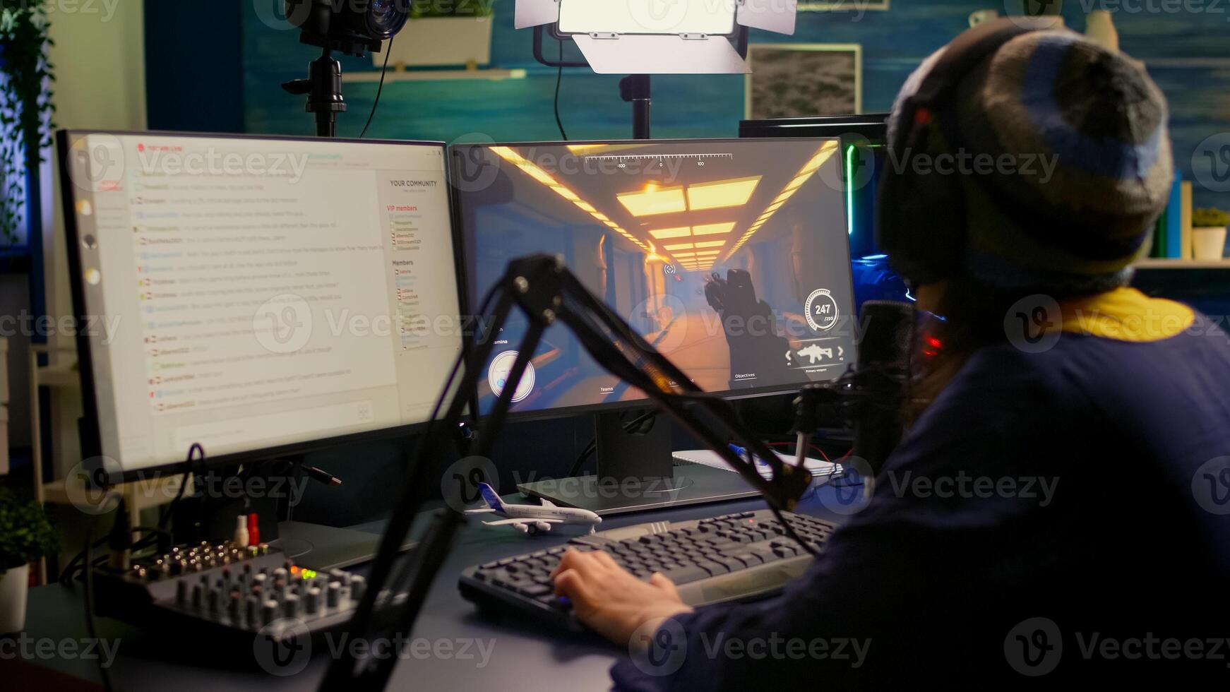 Pro streamer check sound on mixer and start playing first person shooter game during virtual competition. Gamer using professional streaming setup late at night in gaming home studio photo