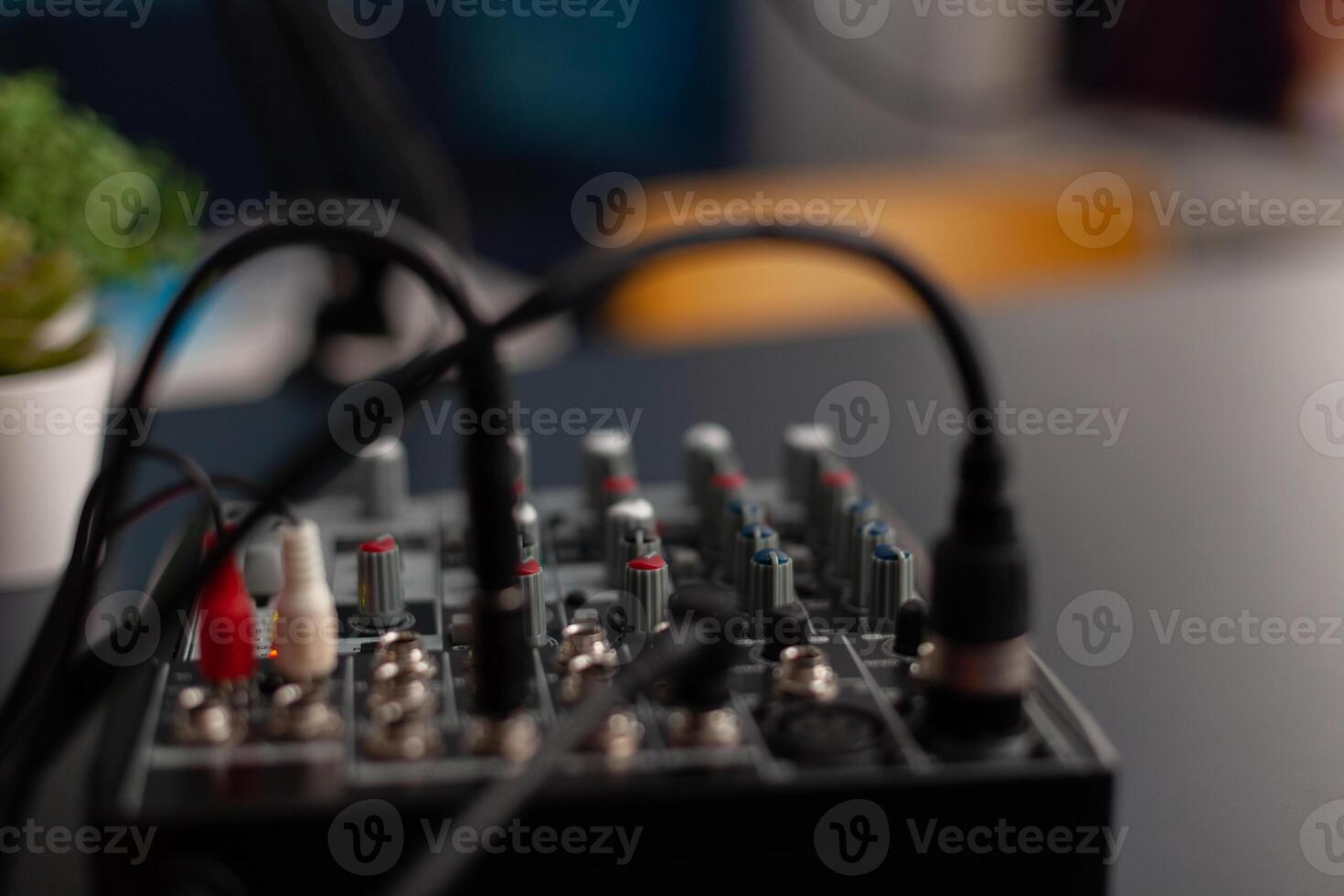 Closeup of professional recording equipment on desk. Audio mixer for live broadcast. Podcast electronic console in home studio. Broadcasting mixing desk station used to record sound and dubbing. photo
