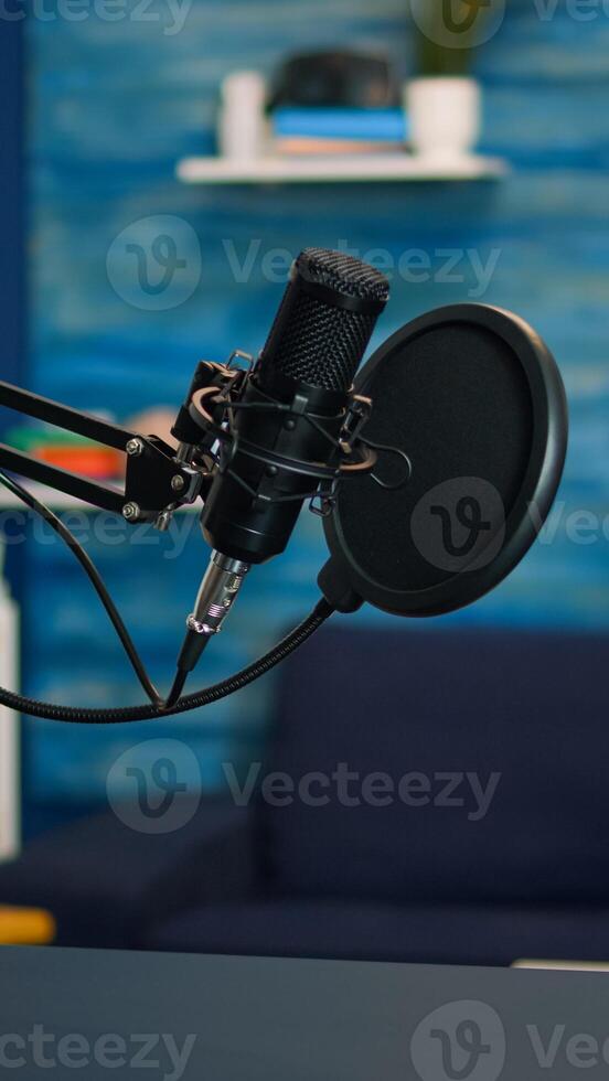 Station for recording and speaking during podcast in night in empty livin room studio. Influencer recording social media content with production microphone, digital web internet streaming station photo