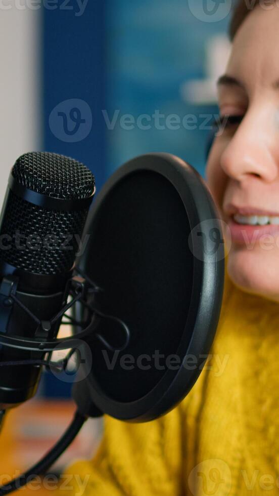 Creative influencer with headphones speaking during livestreaming, blogger discussing in podcast on social media. On-air online production internet broadcast show host streaming live content photo