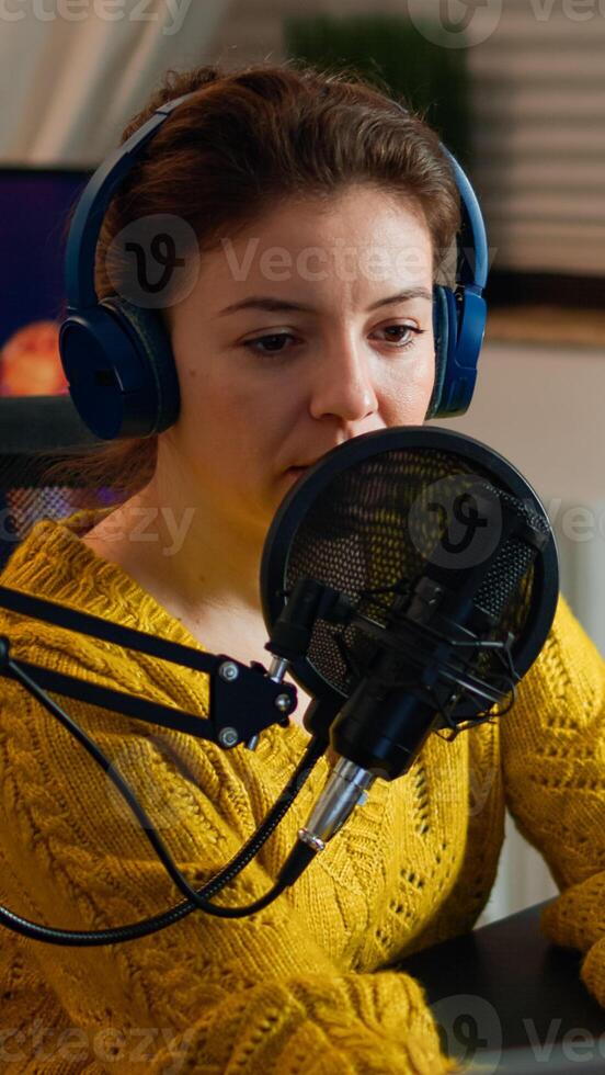 Internet show host answering at questions of fan texting on phone and talking at microphone from home podcast studio. Show production broadcast presenter streaming live content recording digital media photo